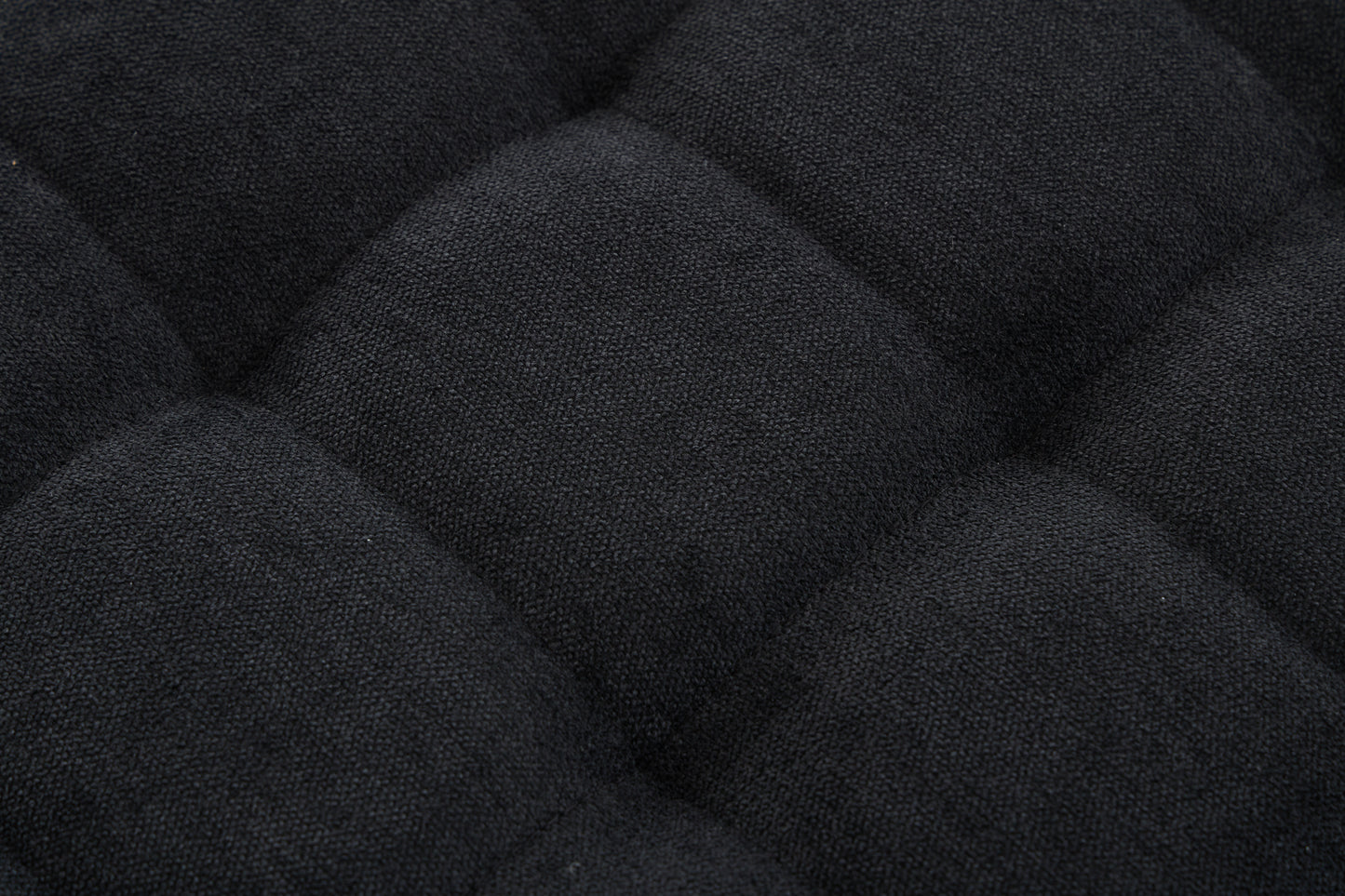 Closeup of black textured fabric with diamond quilting