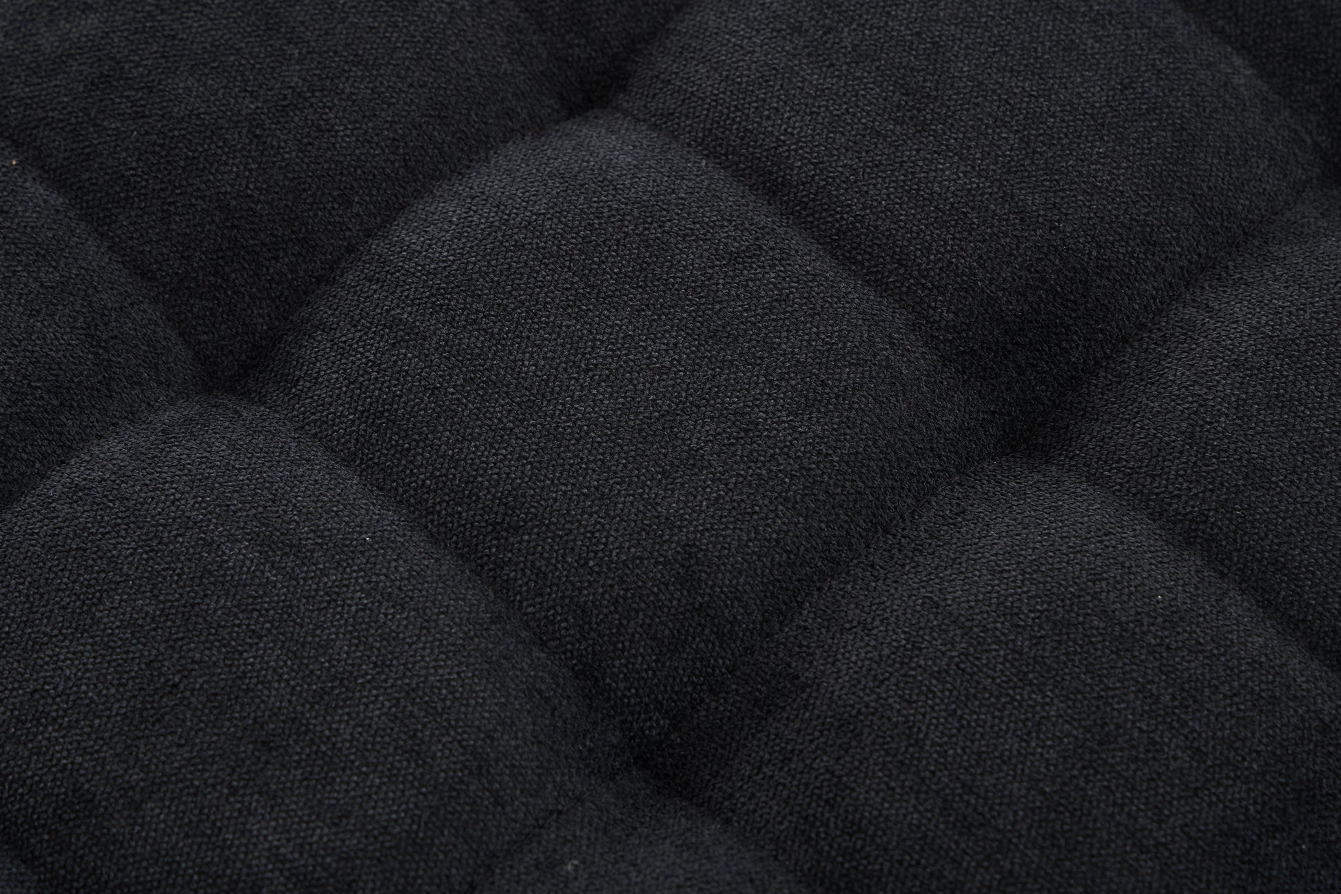 Closeup of black textured fabric with diamond quilting