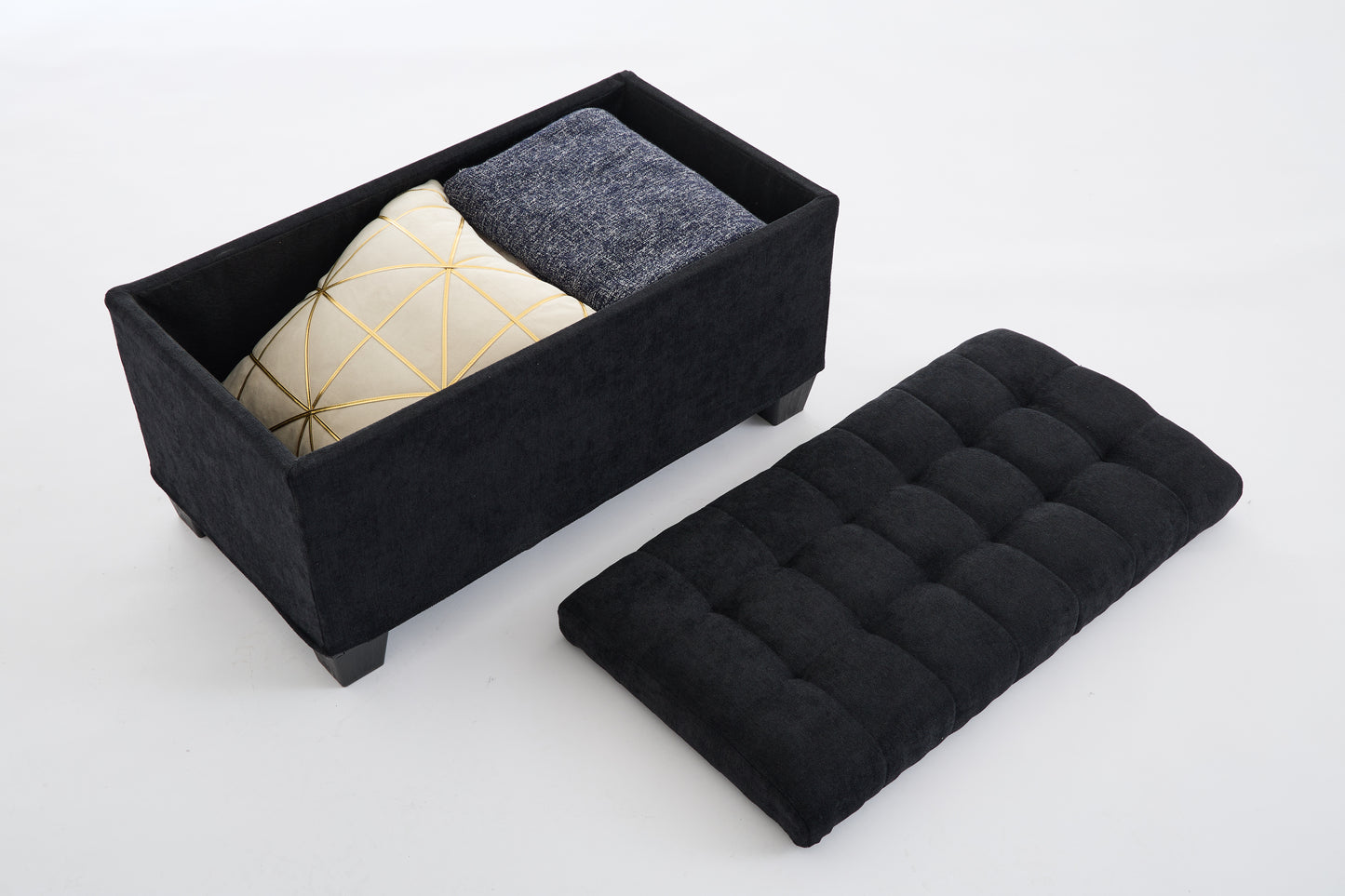 Black fabric storage ottoman with tufted lid and interior pillows