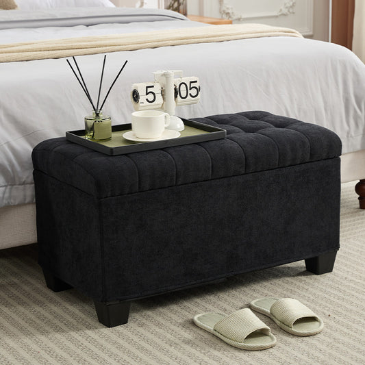 Black tufted storage ottoman with padded seat and dark wood legs