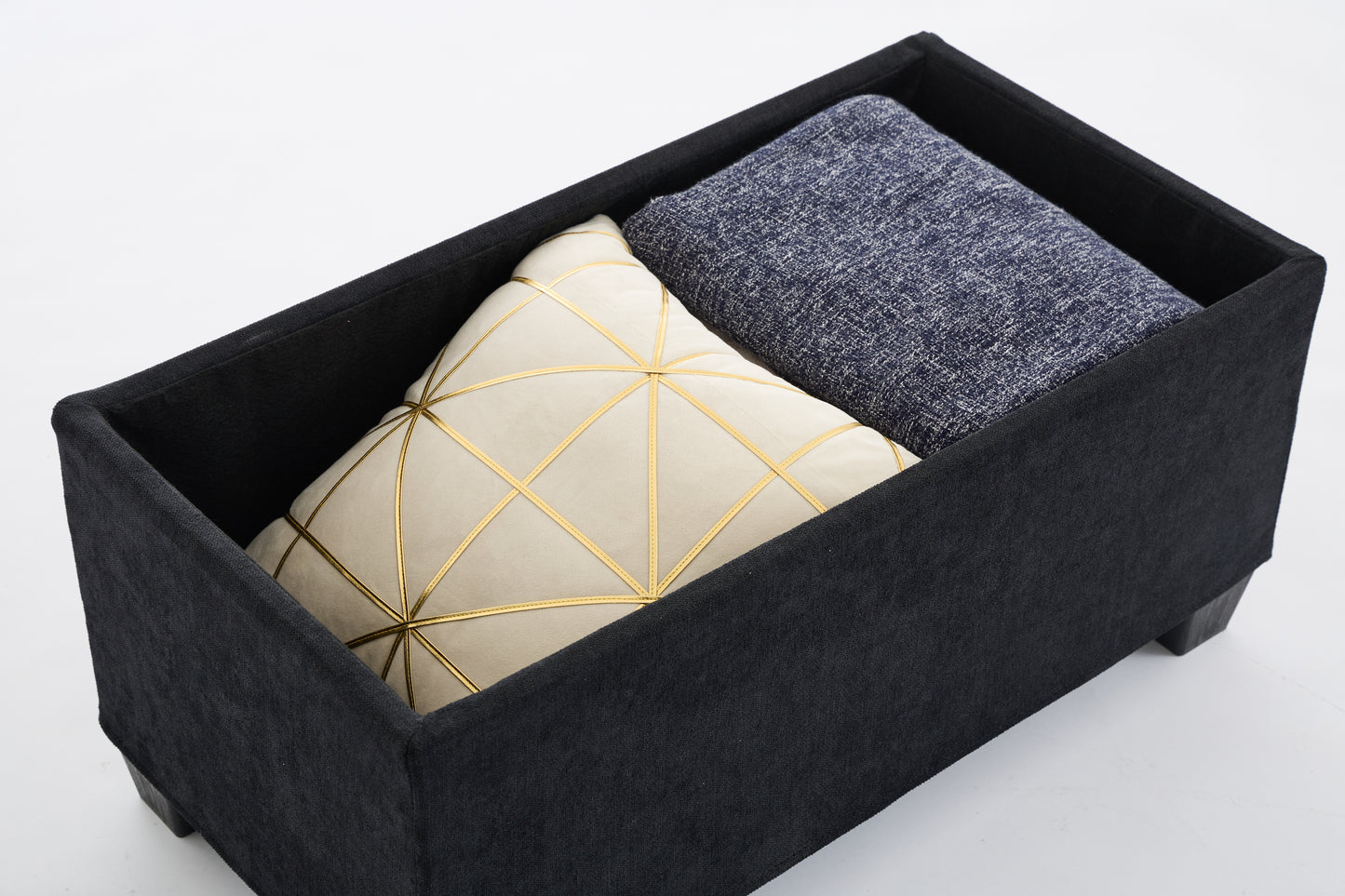 Black storage ottoman with beige geometric pillow and blue throw blanket