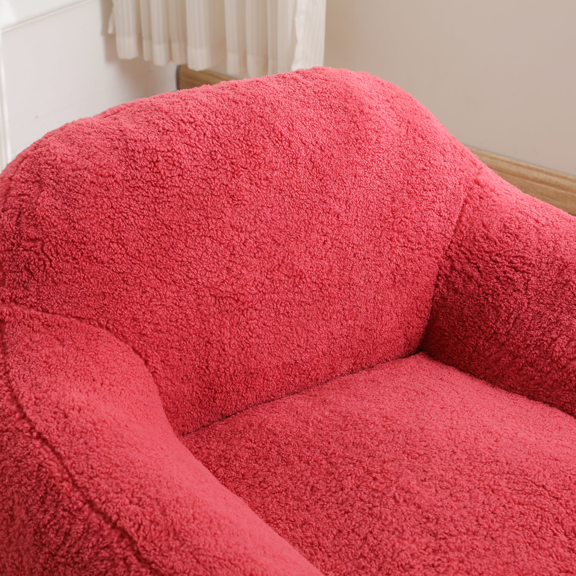 Plush coral velvet armchair with textured fabric and curved armrest perfect for cozy living rooms
