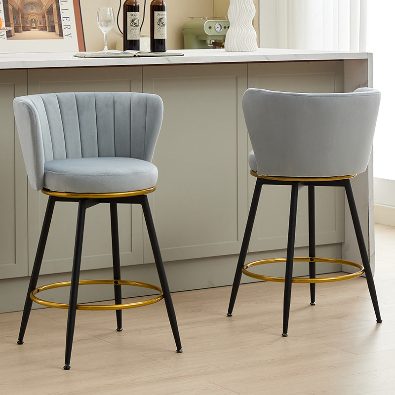 Light blue velvet swivel bar stool with gold ring footrest and black metal legs