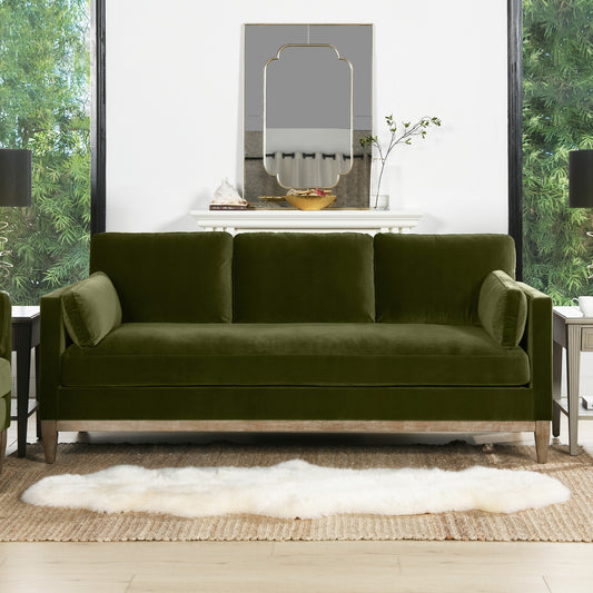 Olive green velvet sofa with plush cushions