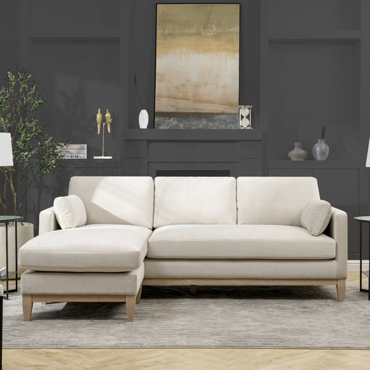 Cream fabric sectional sofa with light wood legs and accent pillows