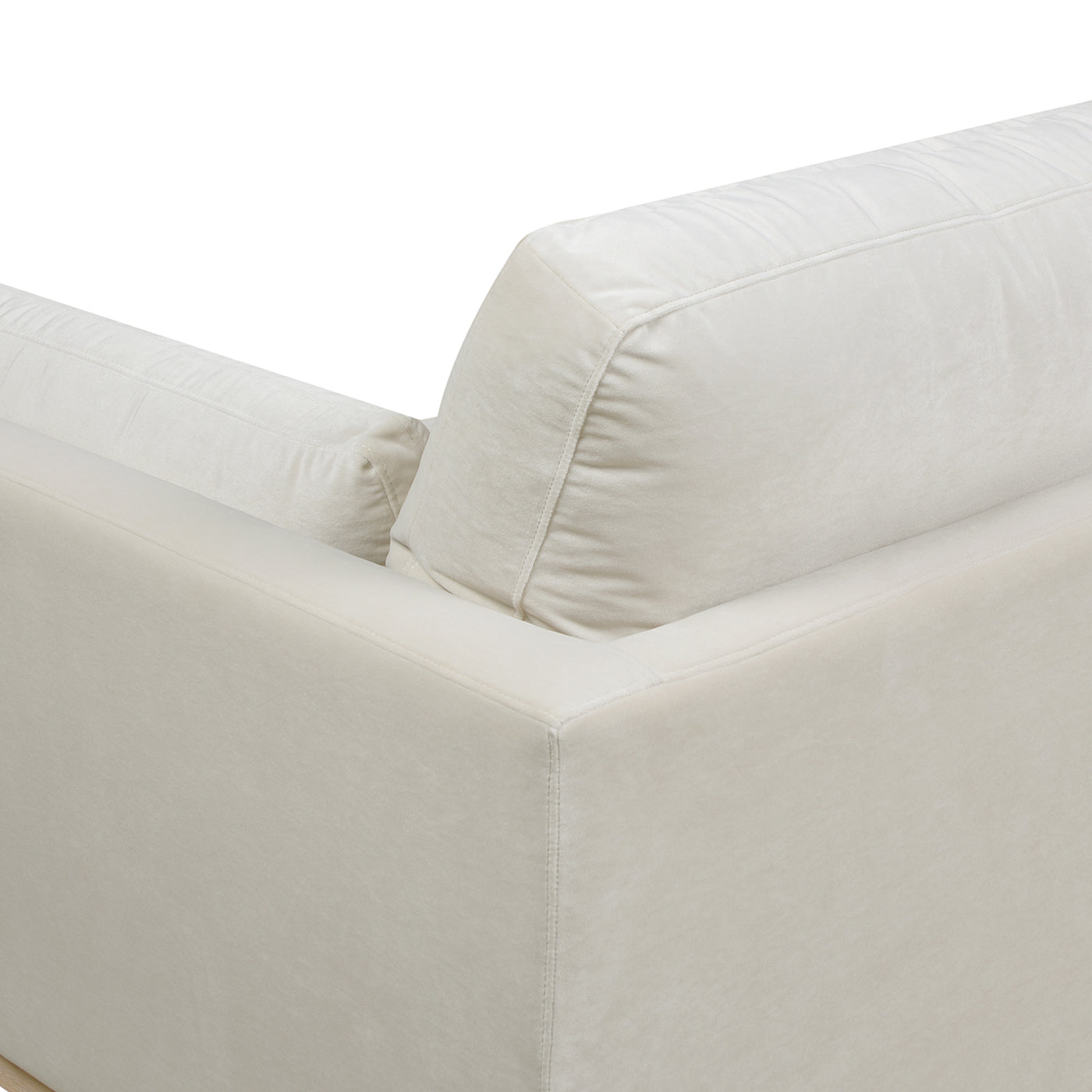 Closeup of a plush ivory velvet sofa armrest with subtle stitching detail