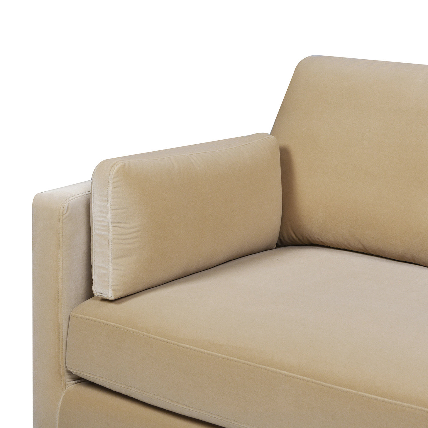 Closeup of a plush beige velvet sofa armrest and cushion