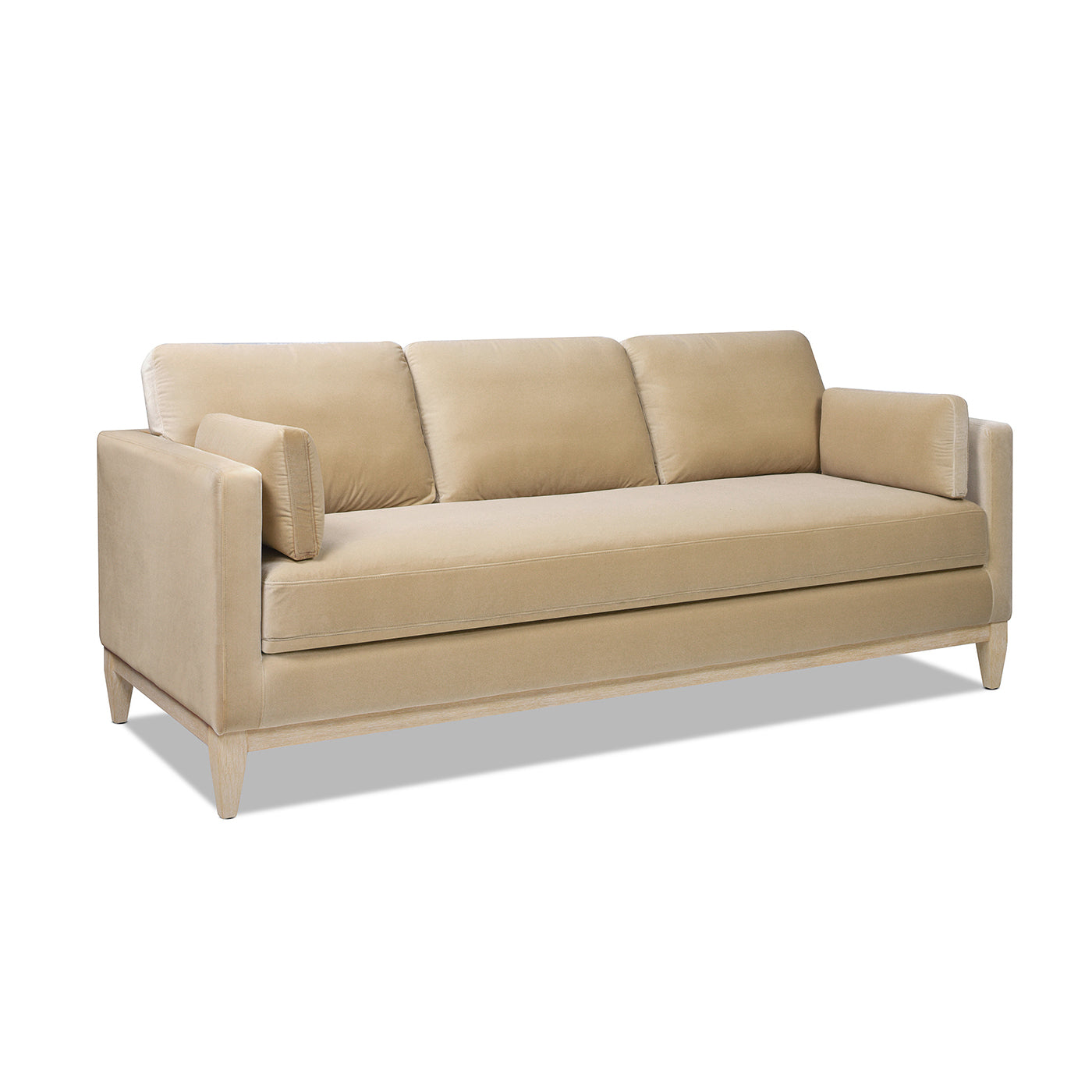 Beige velvet sofa with light wood frame and three plush seat cushions