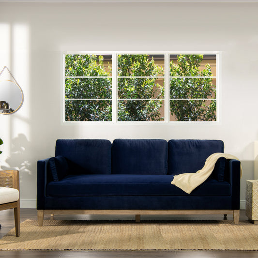 Plush navy velvet sofa with light beige throw