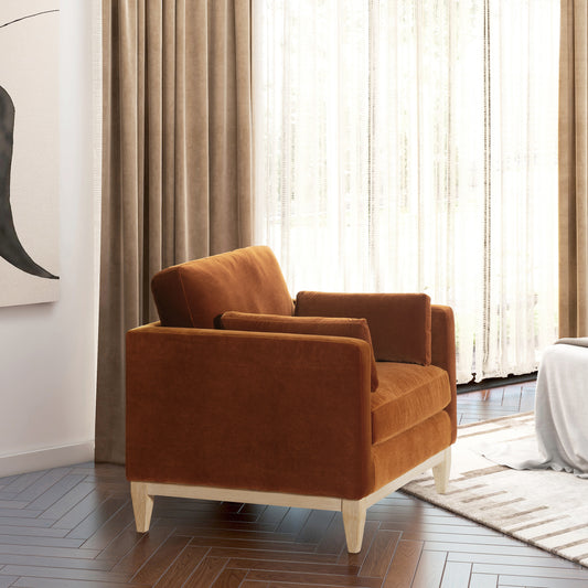 Burnt orange velvet armchair with light wood legs and modern design