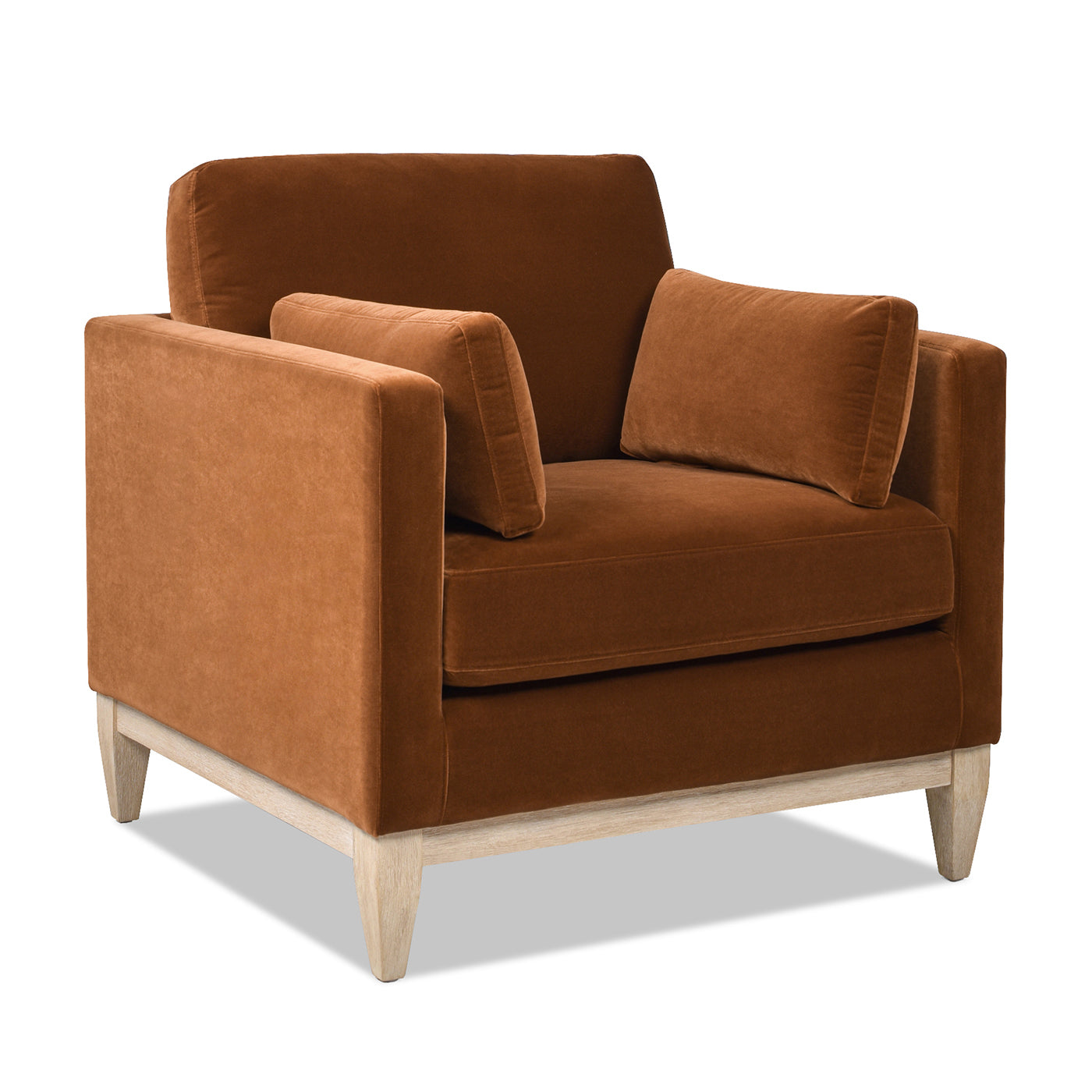 Brown velvet armchair with light wood legs and two accent pillows