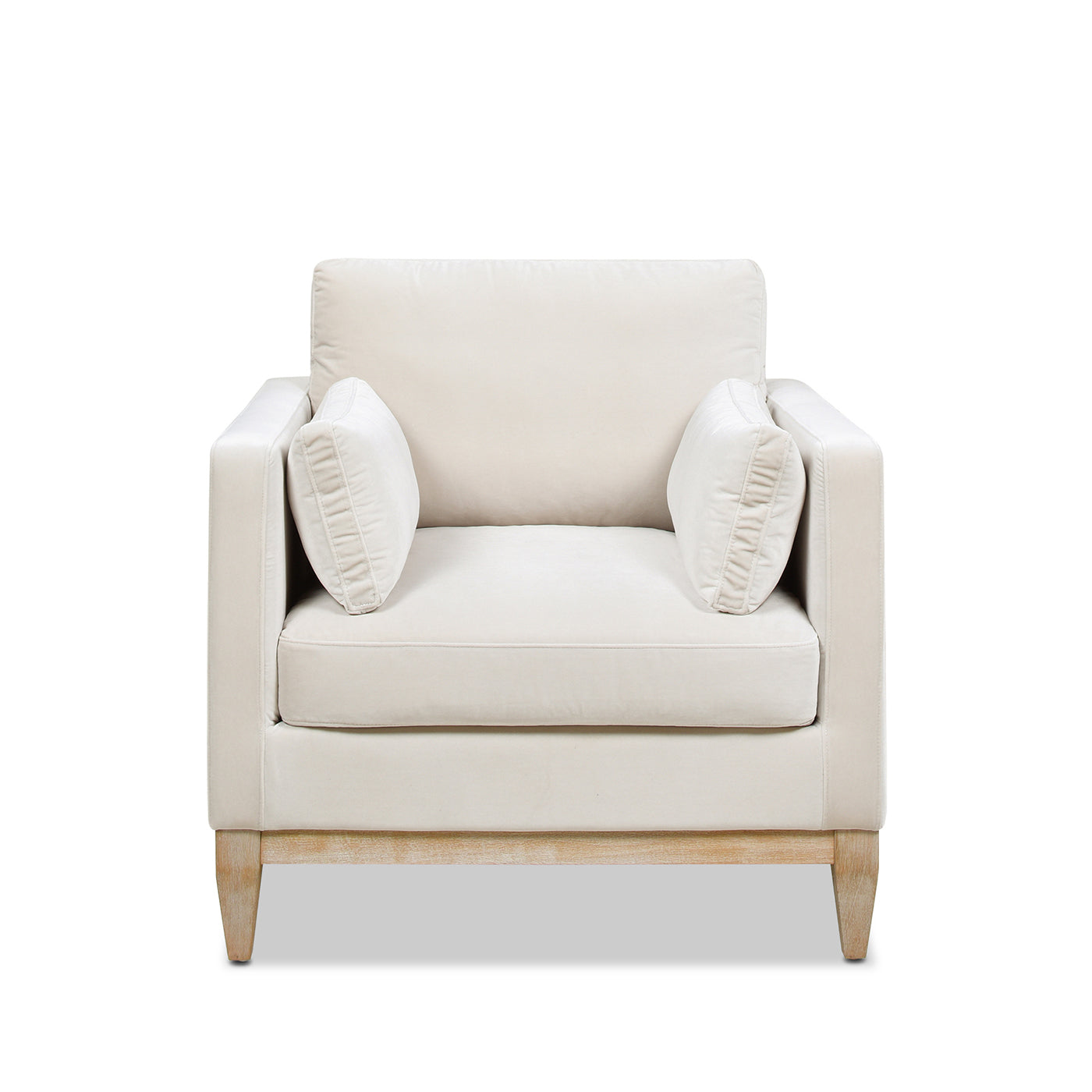 Cream velvet armchair with lumbar pillows and light wood legs