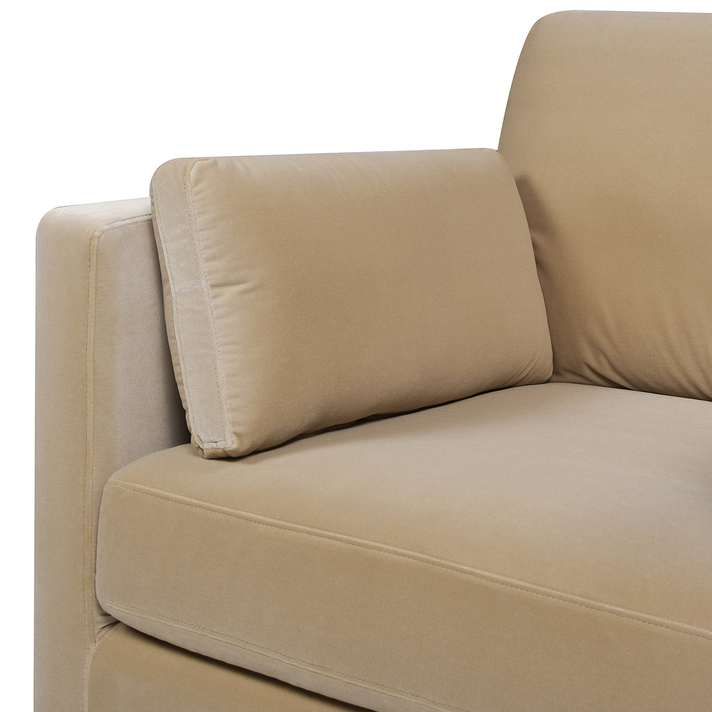 Closeup of a plush beige velvet sofa armrest and cushion