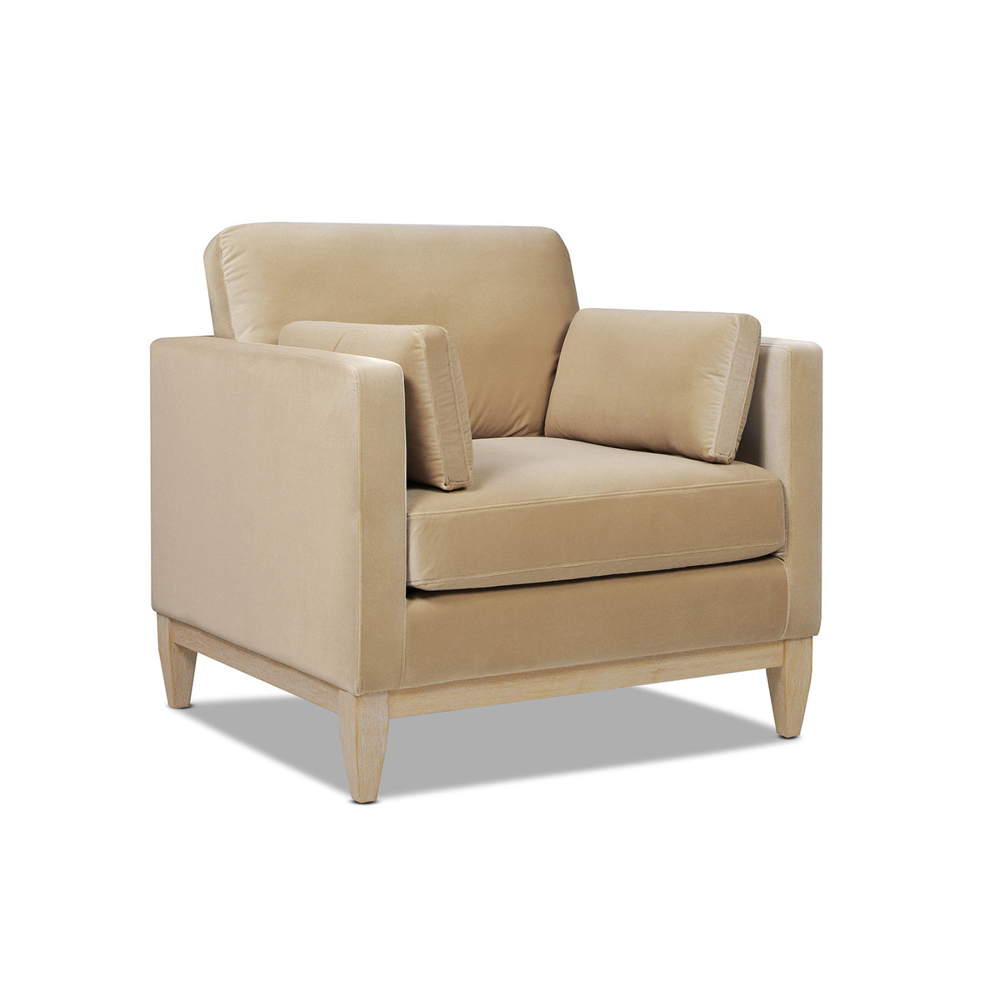 Beige velvet accent chair with plush throw pillows and tapered wooden legs