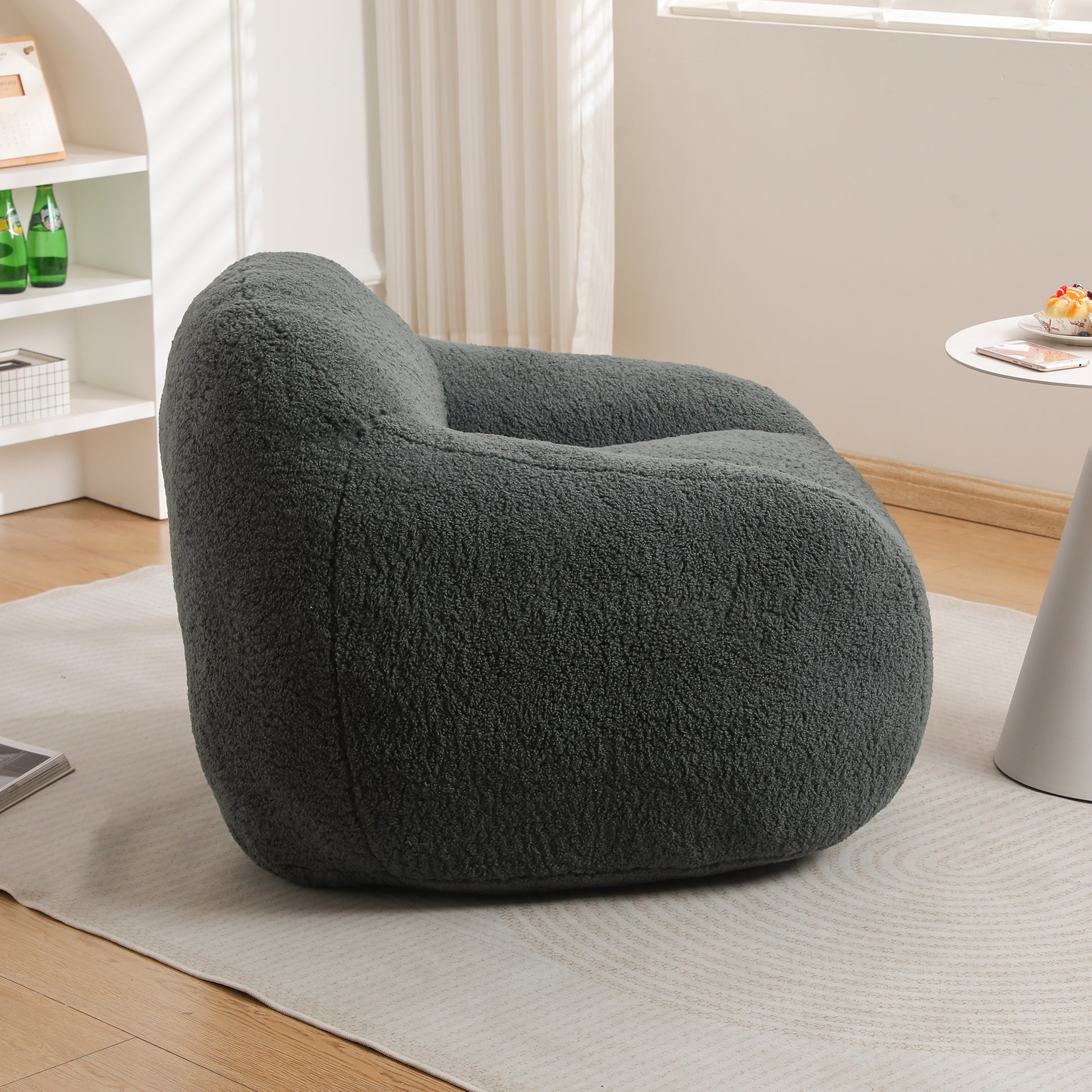 Dark gray plush armchair with rounded silhouette