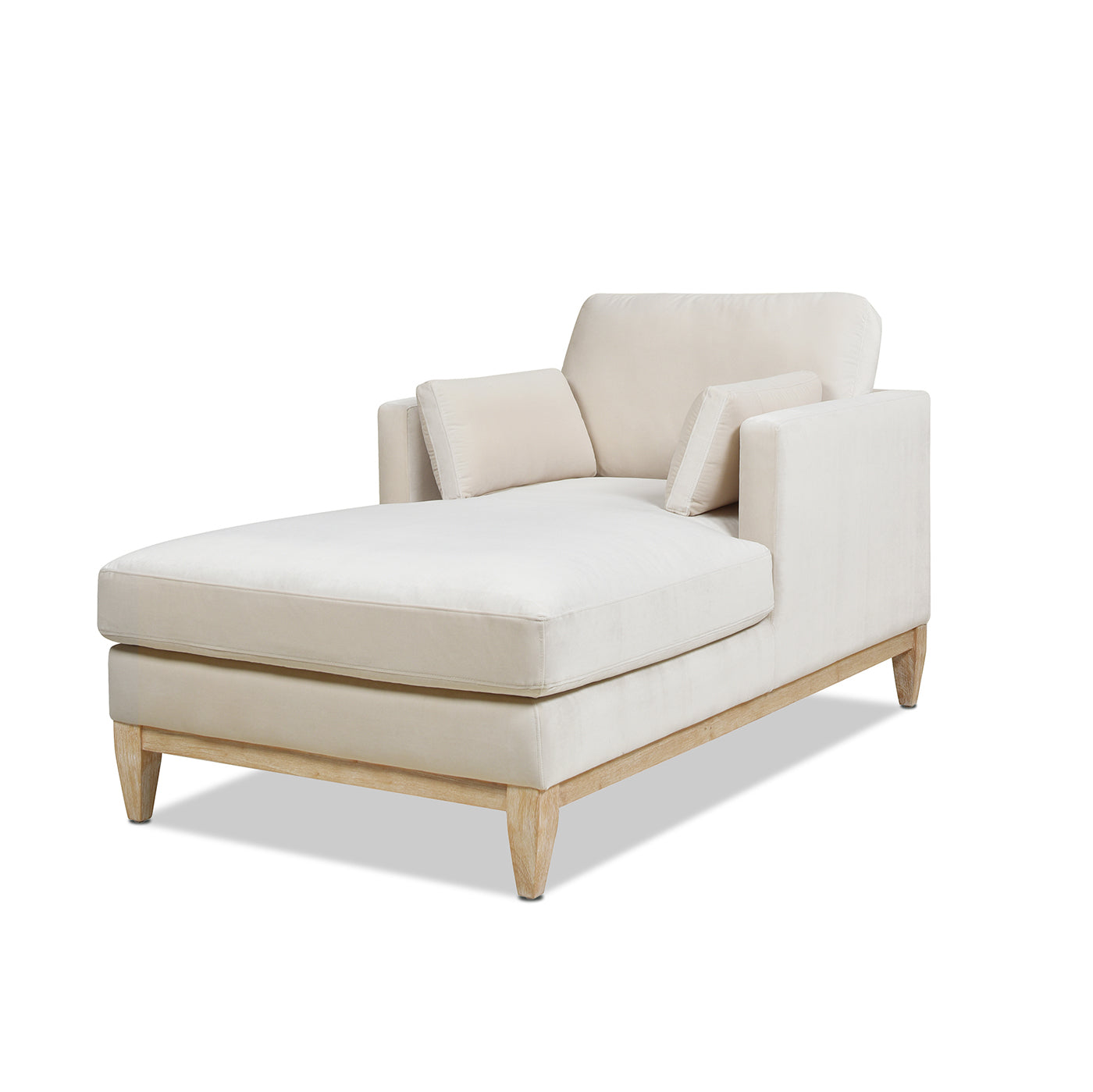 Cream velvet chaise lounge with light wood legs and throw pillows