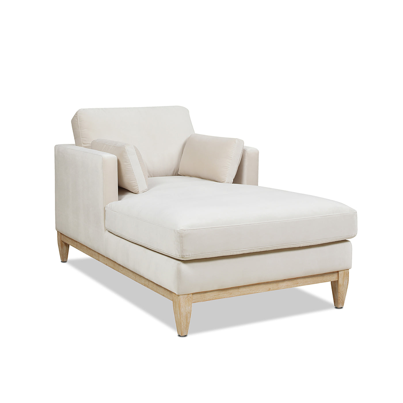 Cream velvet chaise lounge with light wood frame and two throw pillows