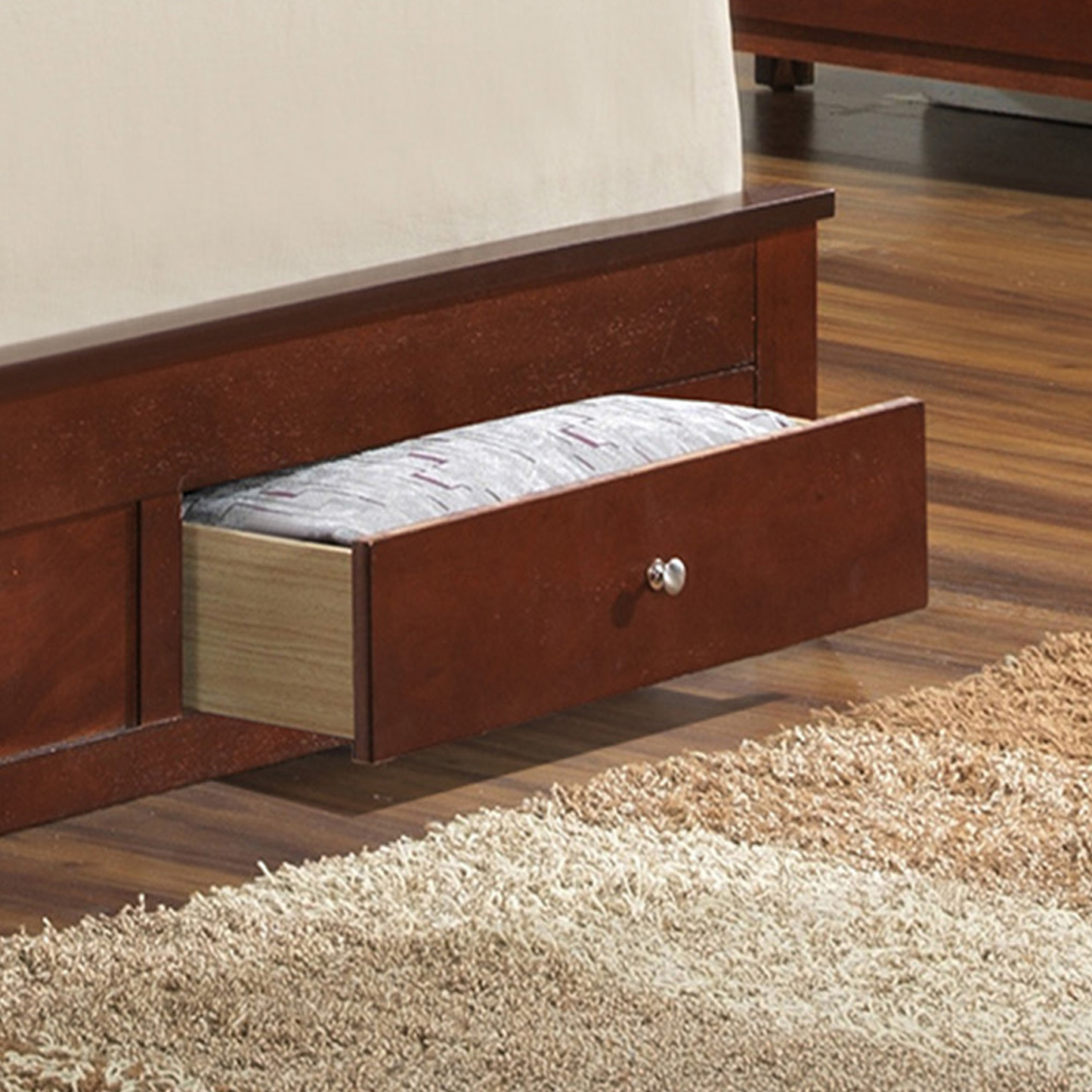 Cherry wood bed frame with open storage drawer and patterned bedding