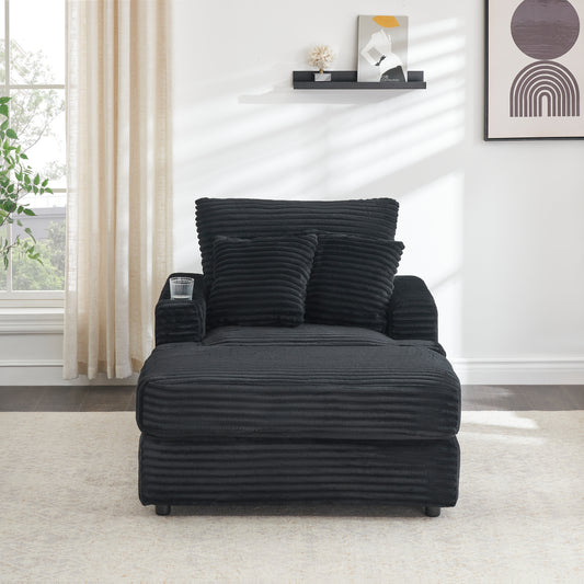 Black corduroy chaise lounge with plush pillows and integrated cup holder