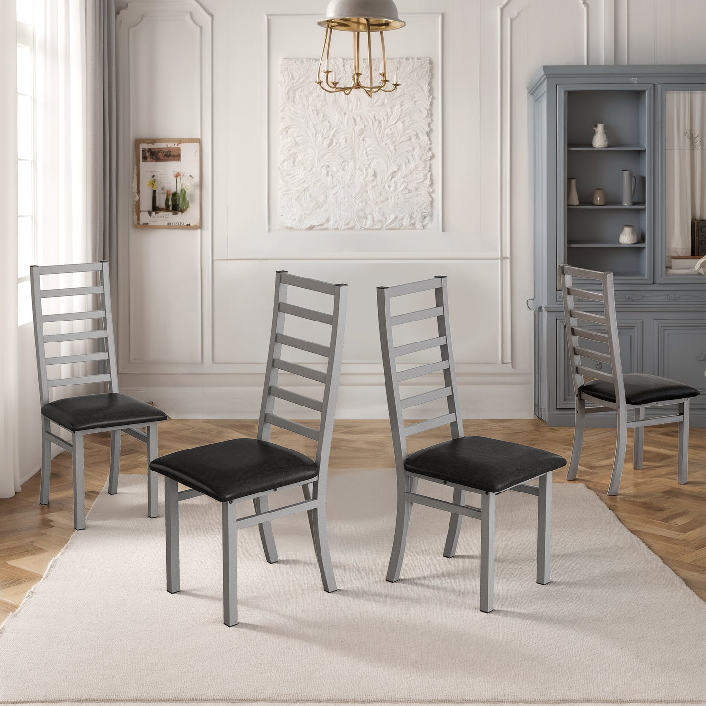 Set of four modern silver dining chairs with black cushioned seats