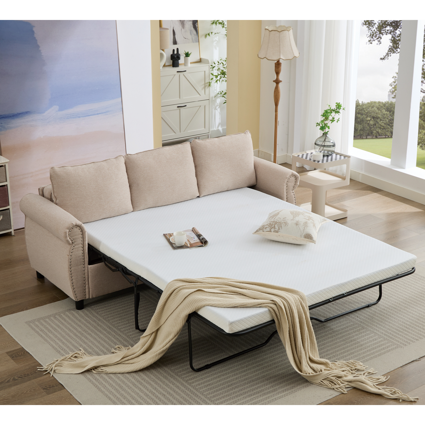 Beige linen sofa bed with studded arms and pulledout mattress for sleeping