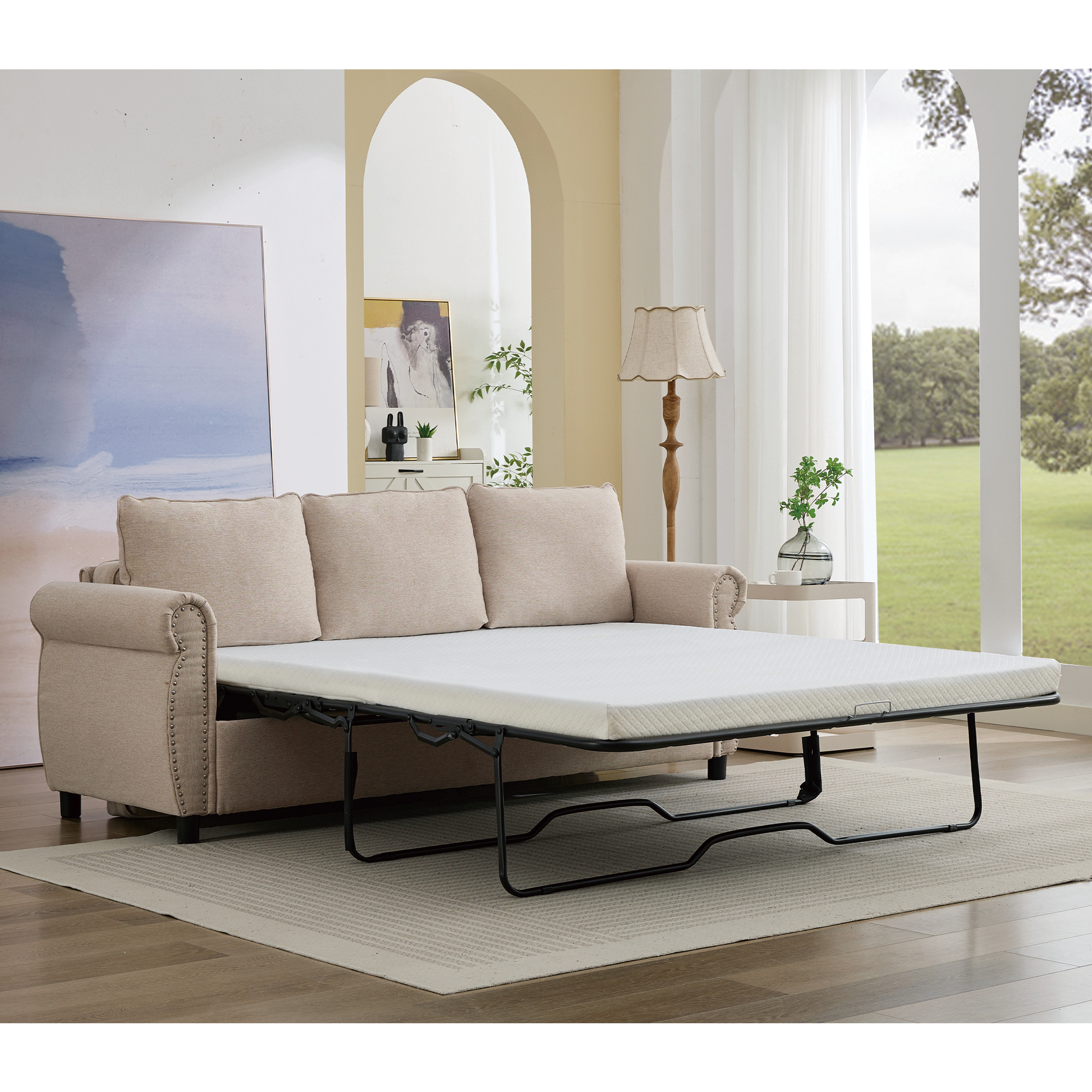 Beige fabric sofa bed with exposed mattress and silver nailhead trim