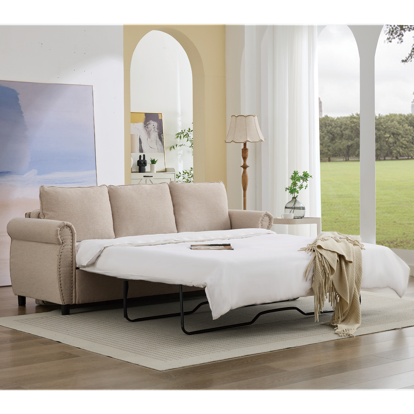 Beige fabric sofa bed with studded armrests pulled out into a bed