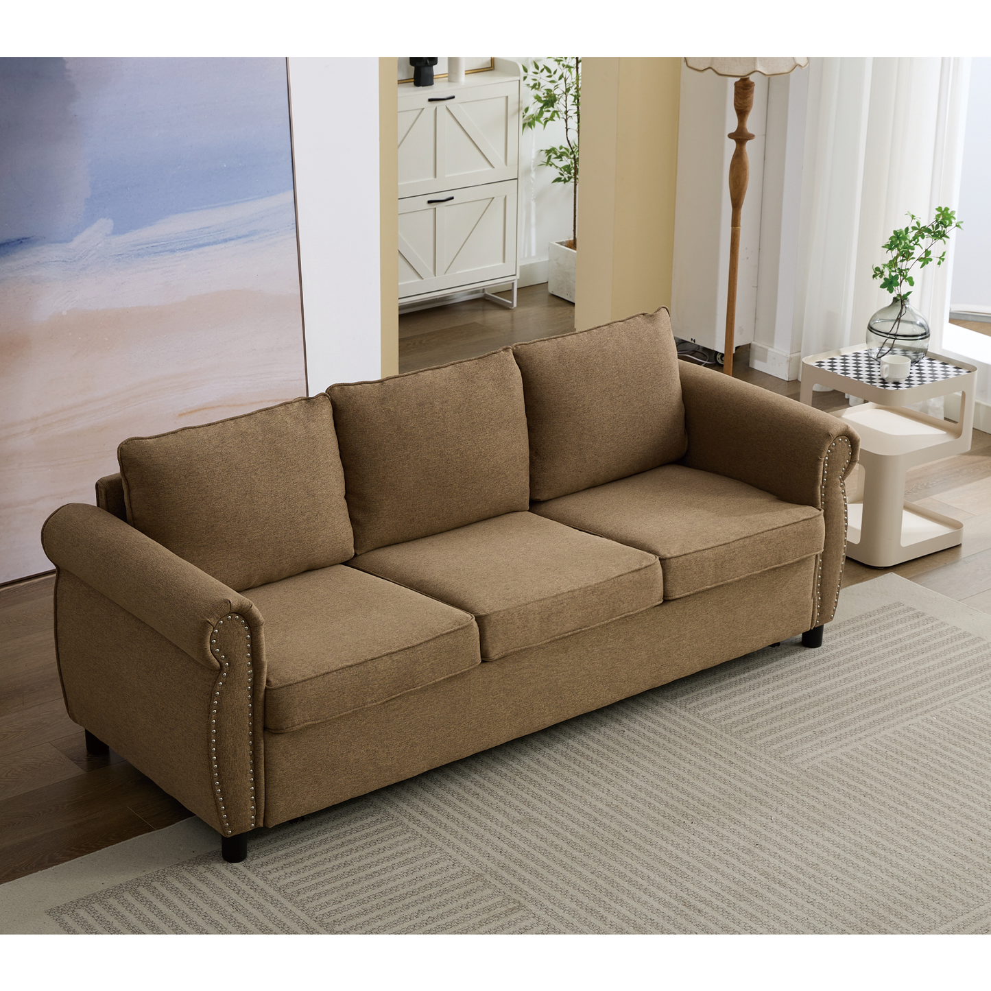 Brown fabric threeseater sofa with studded arms