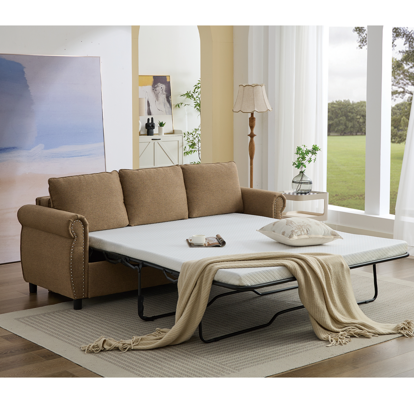 Brown fabric sofa bed with nailhead trim pulled out to reveal mattress and beige throw