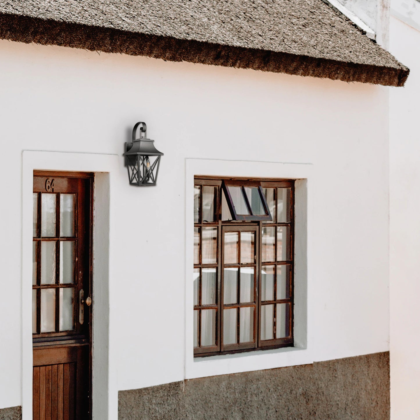 Black wrought iron outdoor lantern with geometric accents mounted next to a wooden door