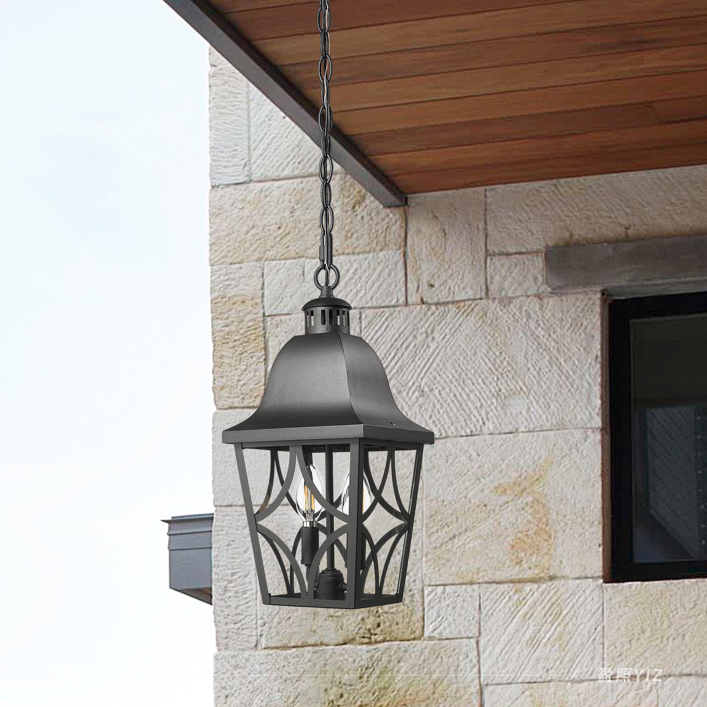 Black metal outdoor hanging lantern with ornate detailing and Edison bulb