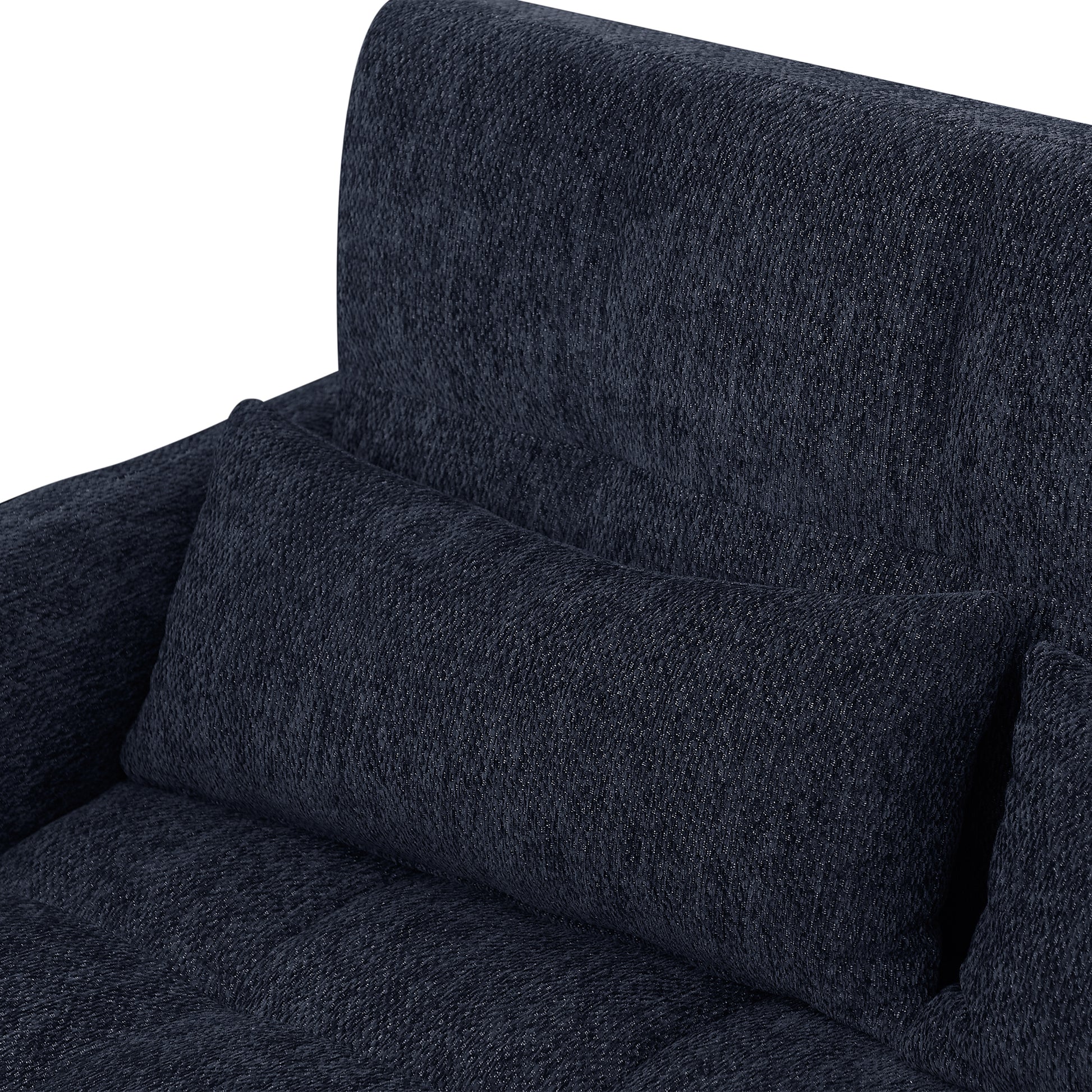 Closeup of a textured dark blue fabric sofa with a lumbar pillow