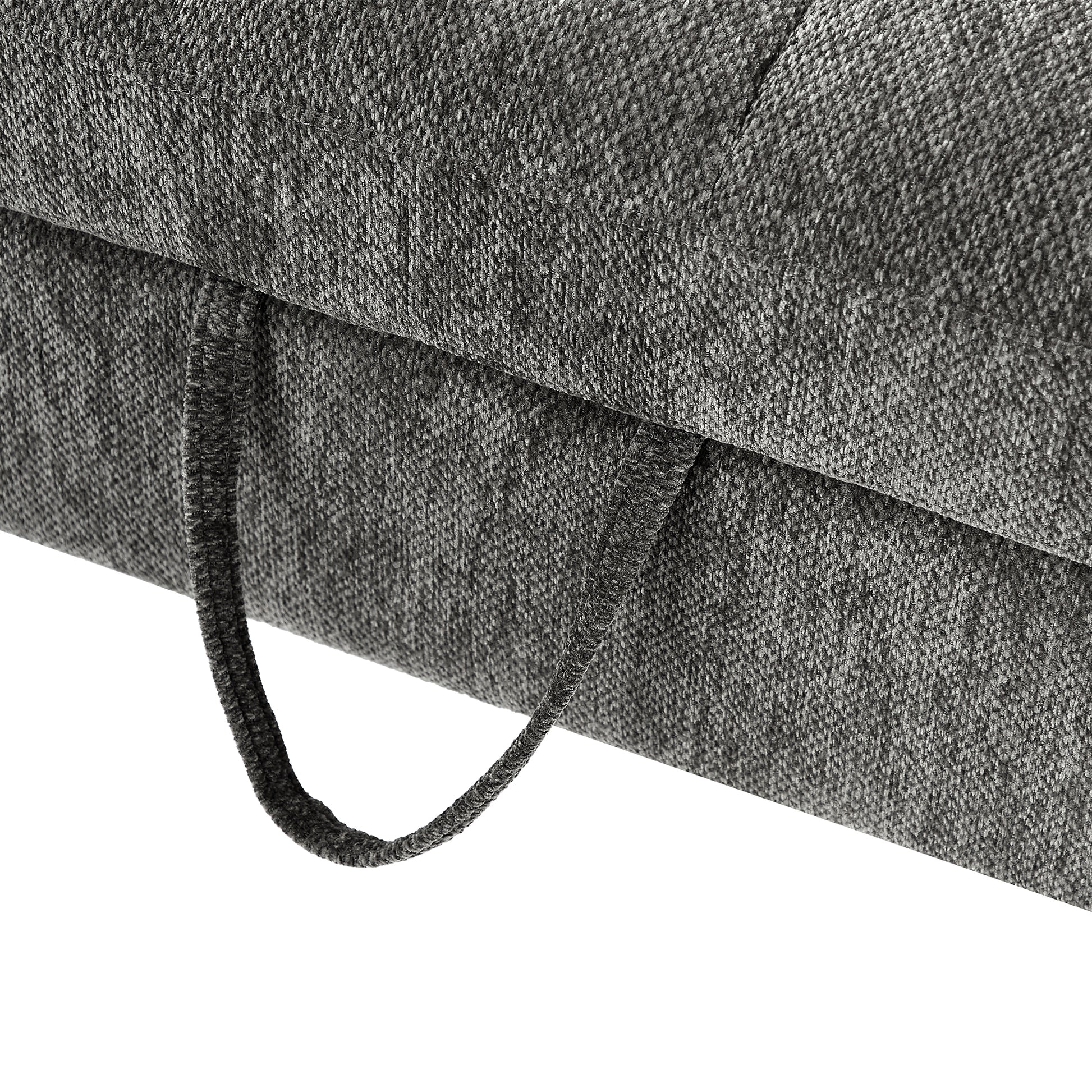 Closeup of textured charcoal grey fabric on a sofa cushion with a pull loop