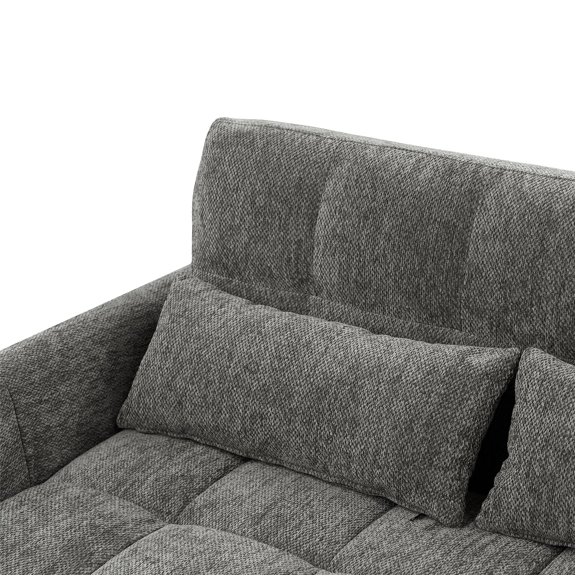 Tufted charcoal gray fabric sofa detail with lumbar pillow