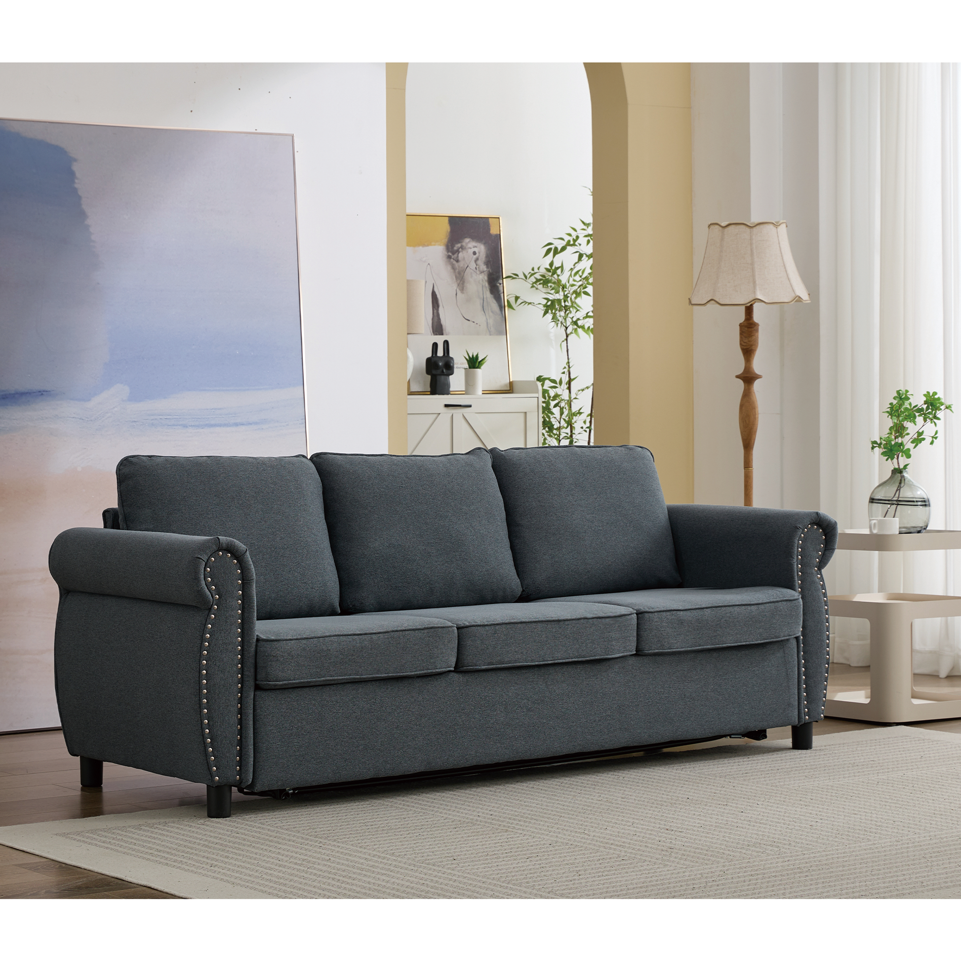 Dark gray fabric sofa with silver nailhead trim and plush cushions