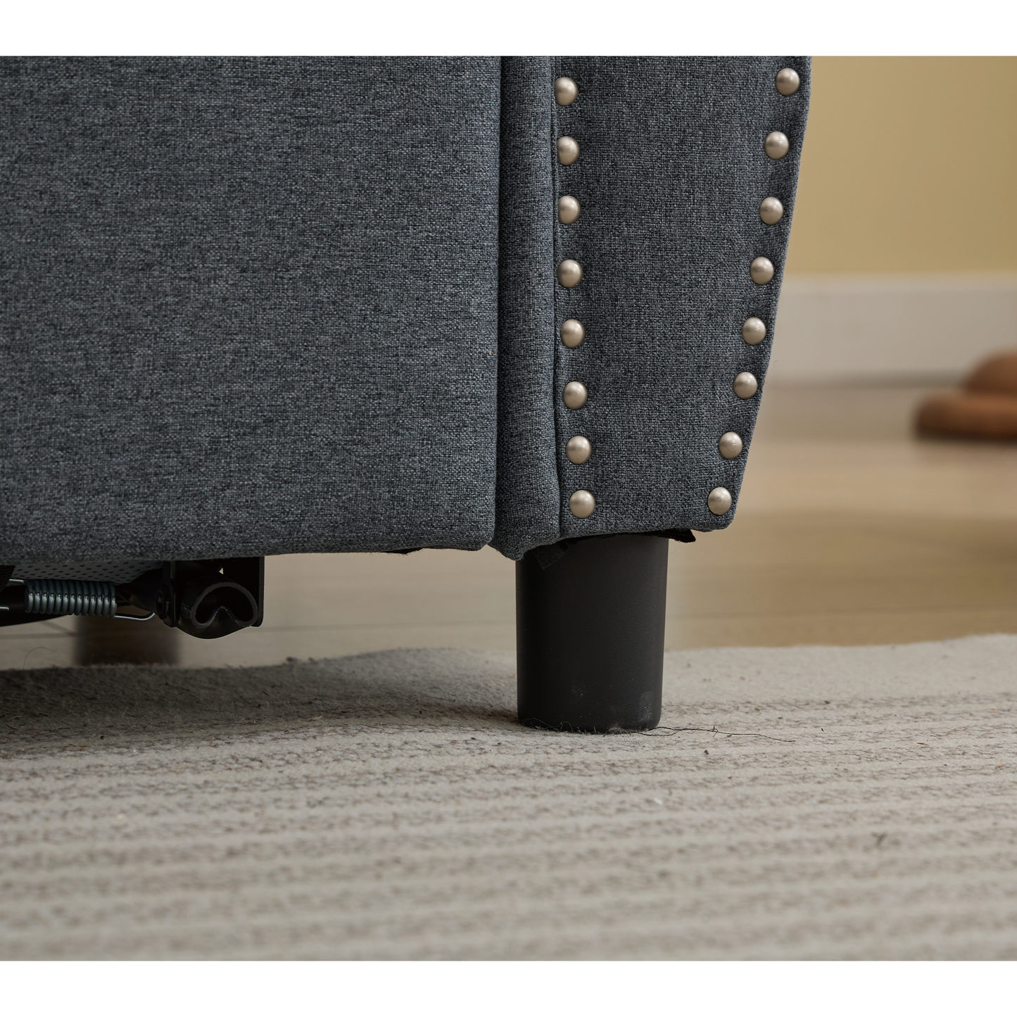 Dark grey fabric armchair corner with silver nailhead trim detail