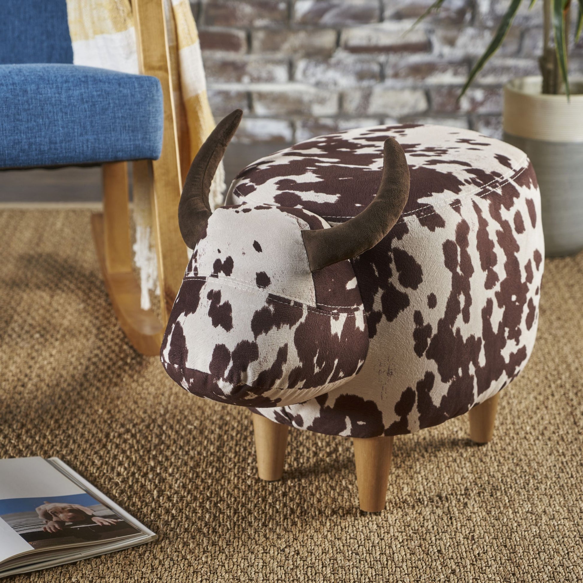 Cow print fabric ottoman with brown suede horns and wood legs