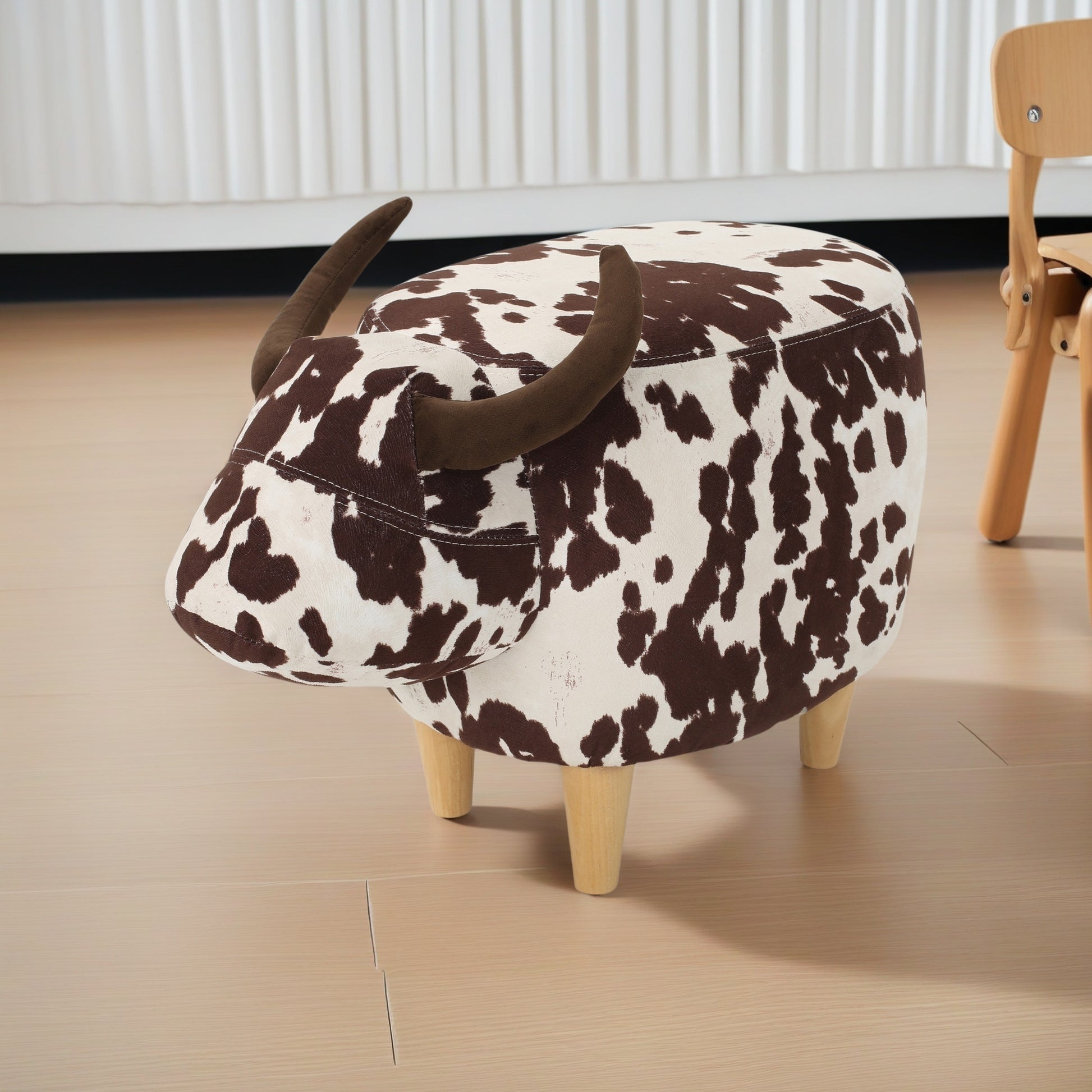 Brown and white cow print ottoman with horns and wooden legs