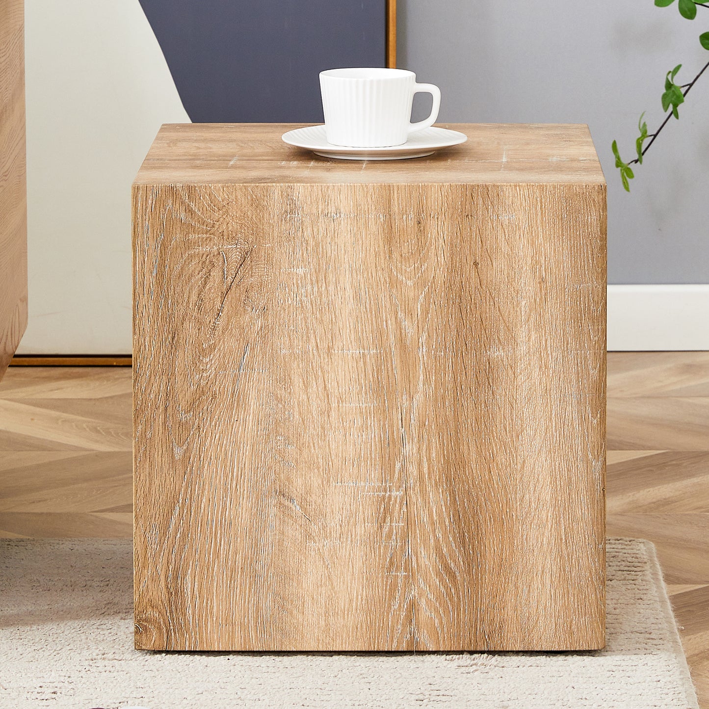 Light oak cube side table with textured wood grain and a white coffee cup