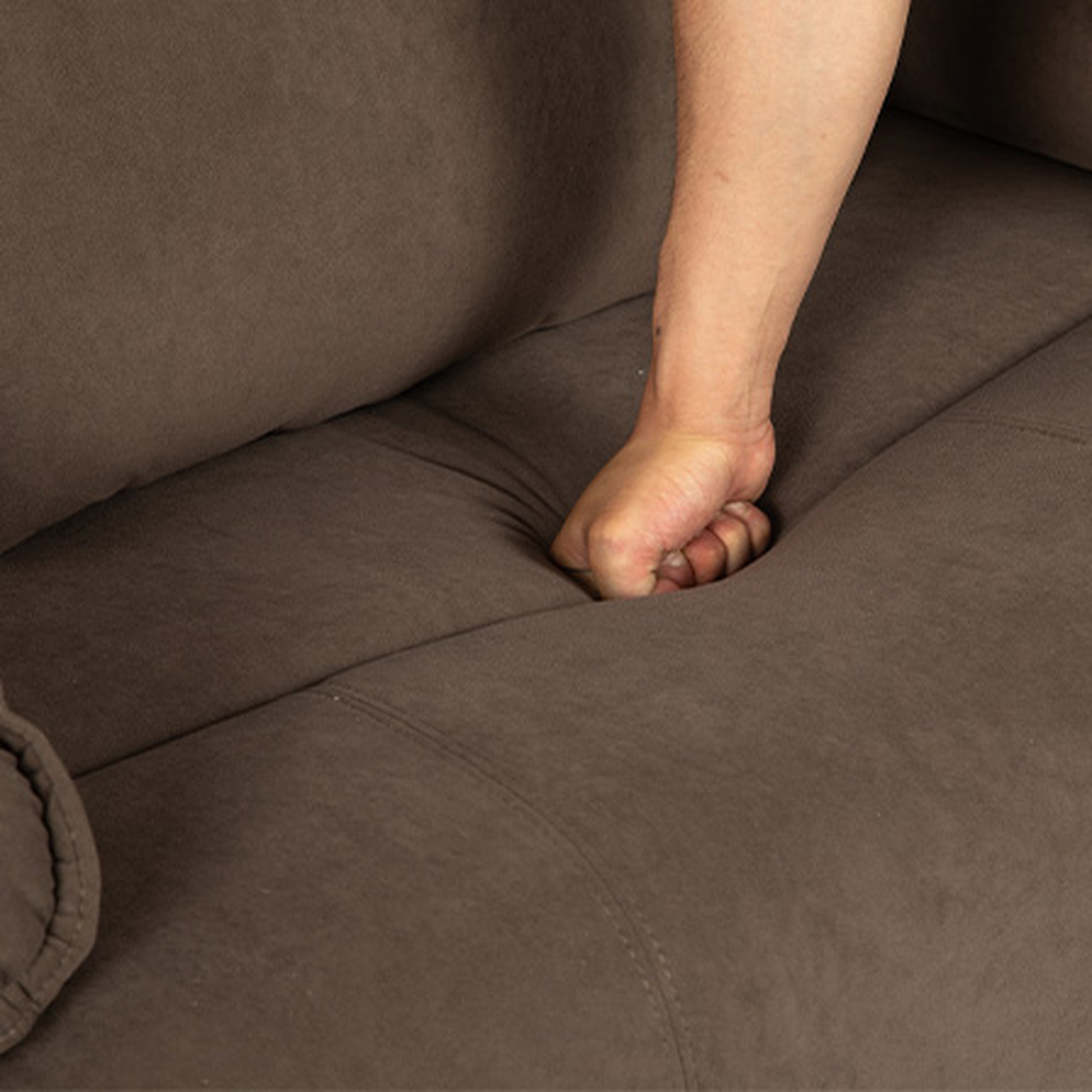 Brown fabric sofa cushion with hand indent