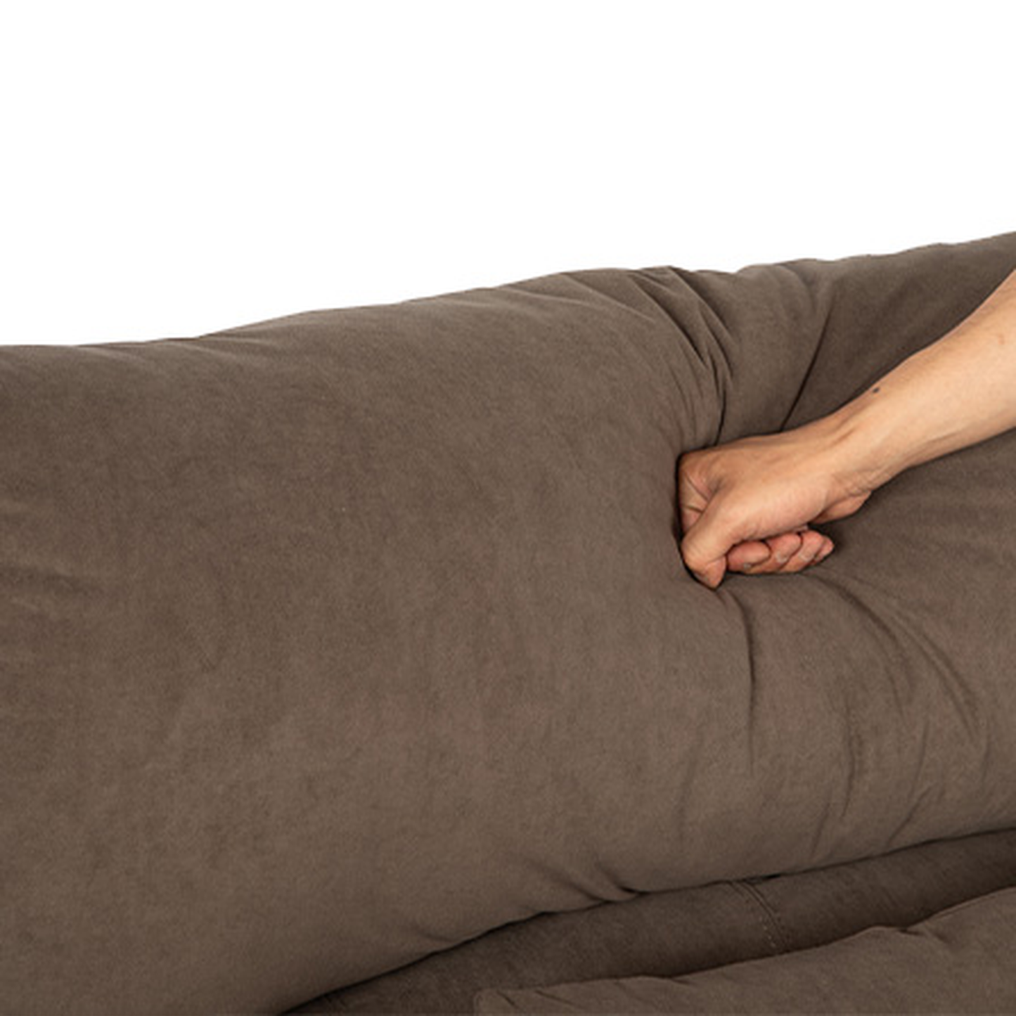 Brown plush sofa cushion being tested for softness