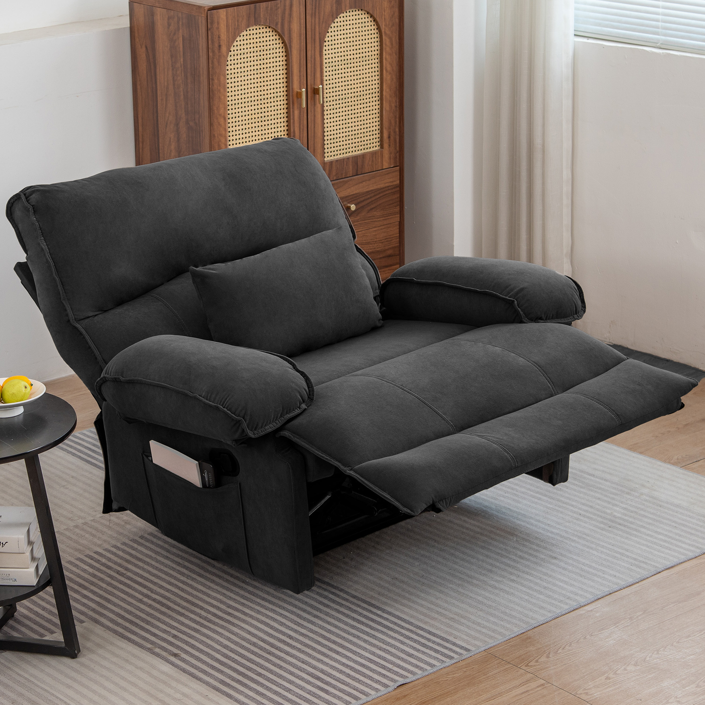 Dark gray fabric recliner with padded armrests and footrest extended