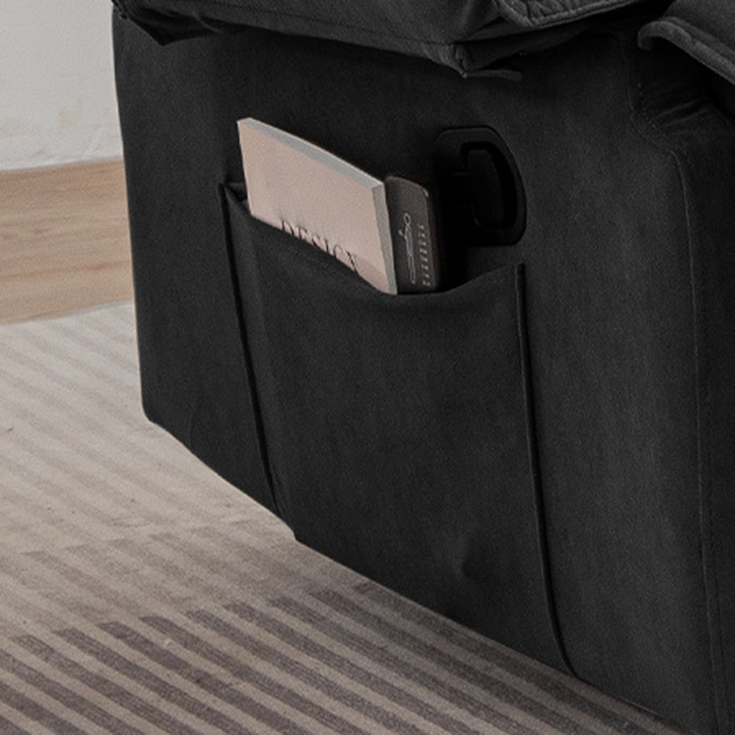 Black recliner side pocket with a book and remote
