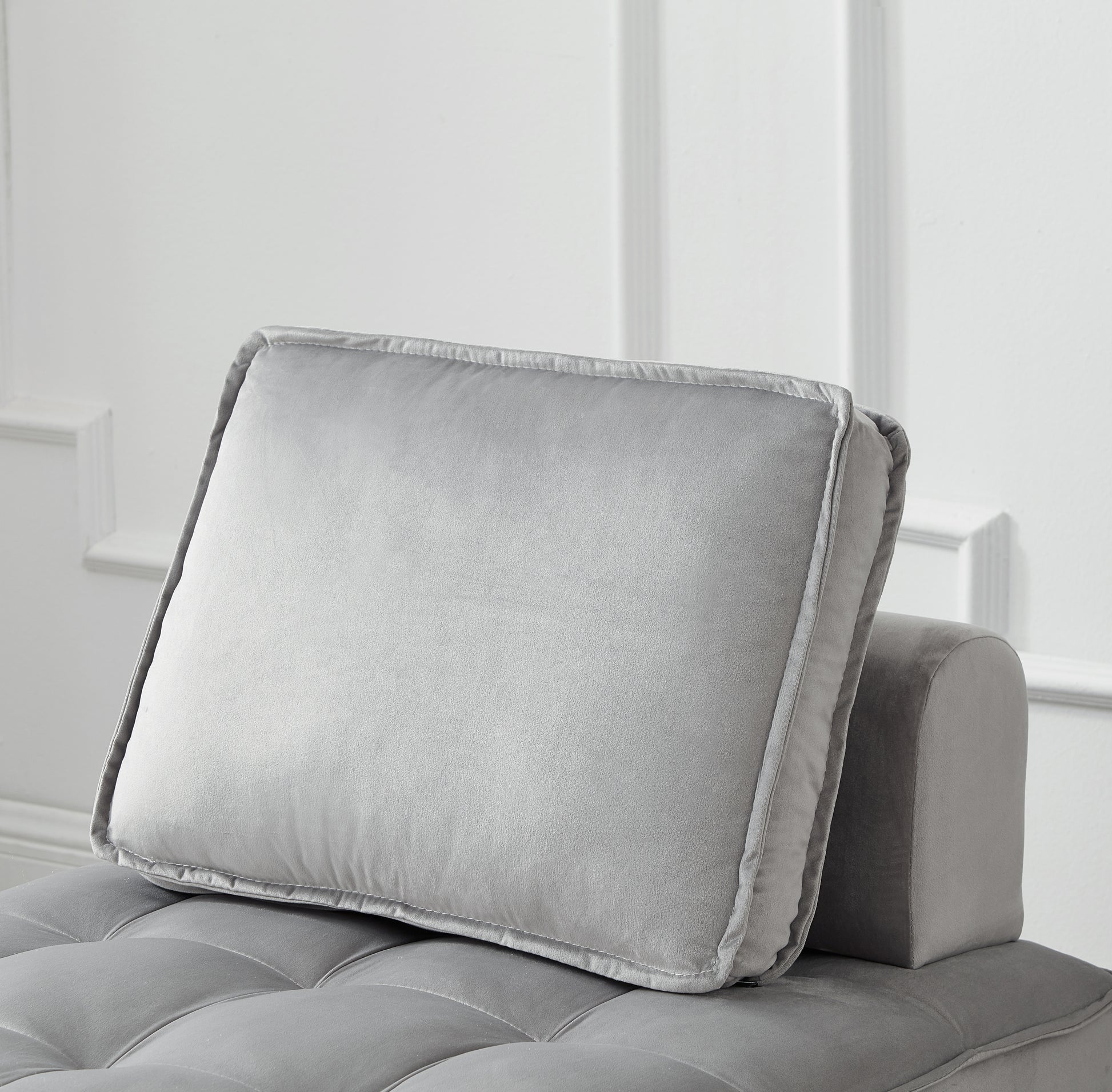 Plush grey velvet throw pillow with detailed stitching and piping