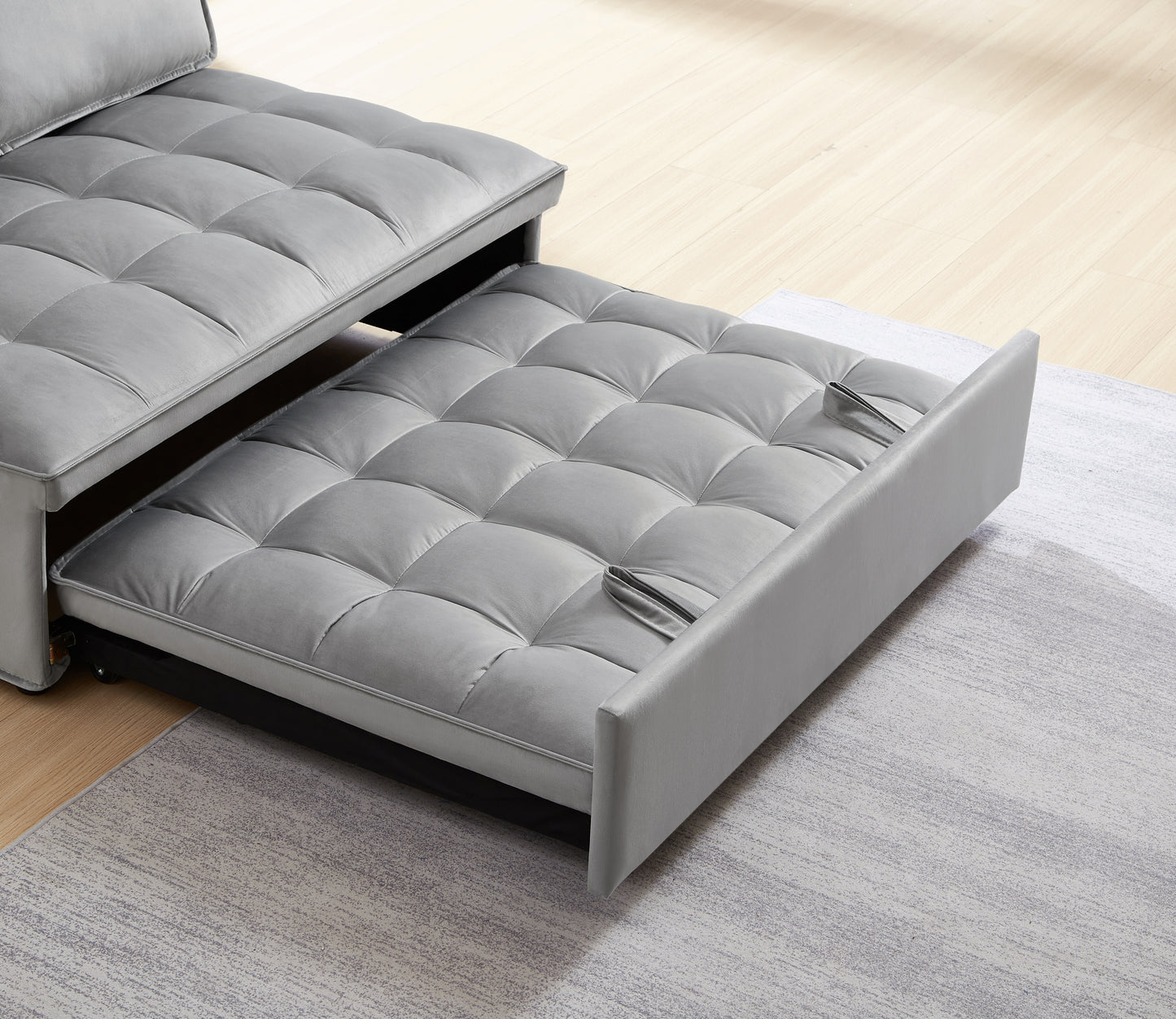 Grey velvet sofa bed with tufted cushions and pullout sleeping section