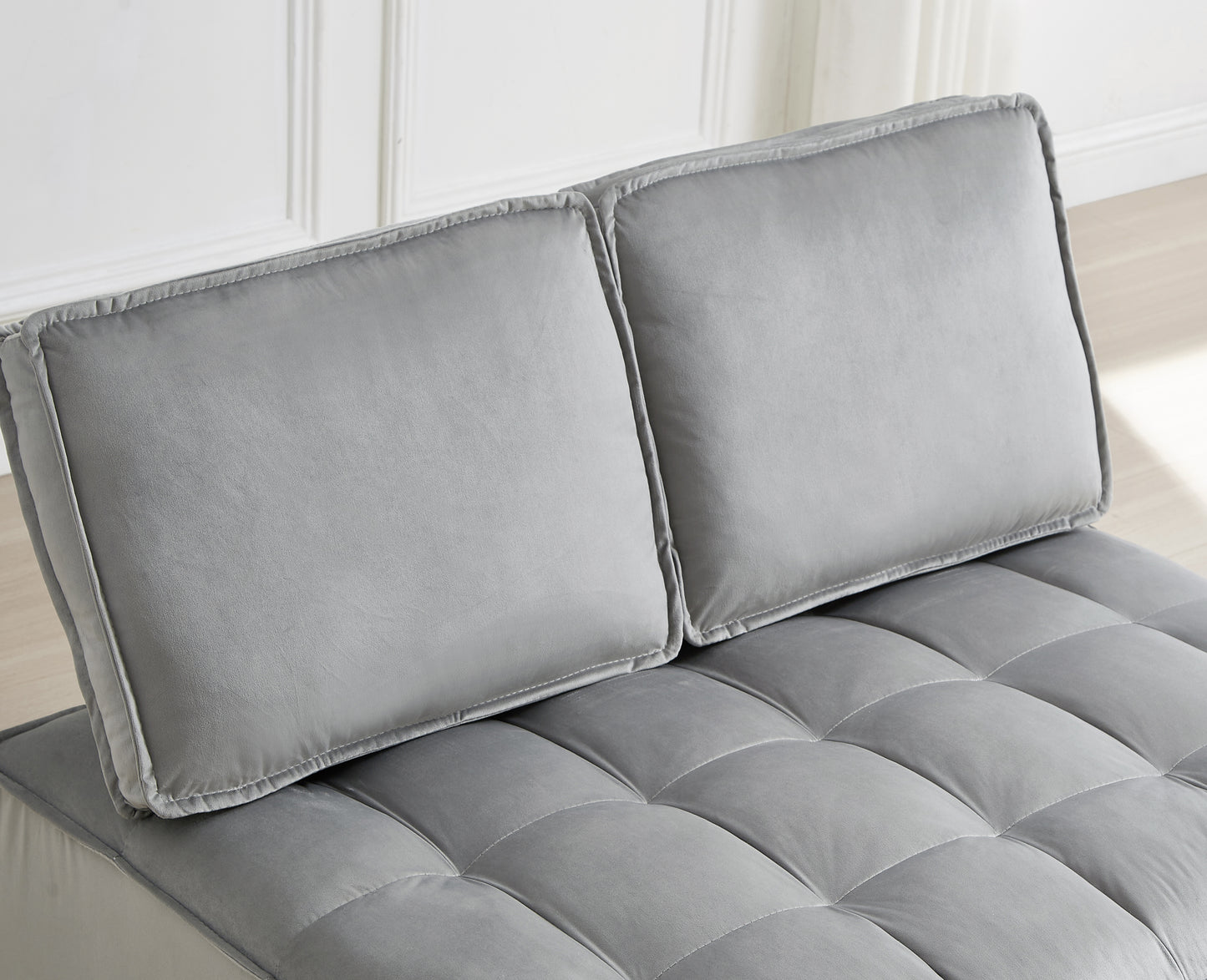 Grey velvet tufted sofa with plush cushions