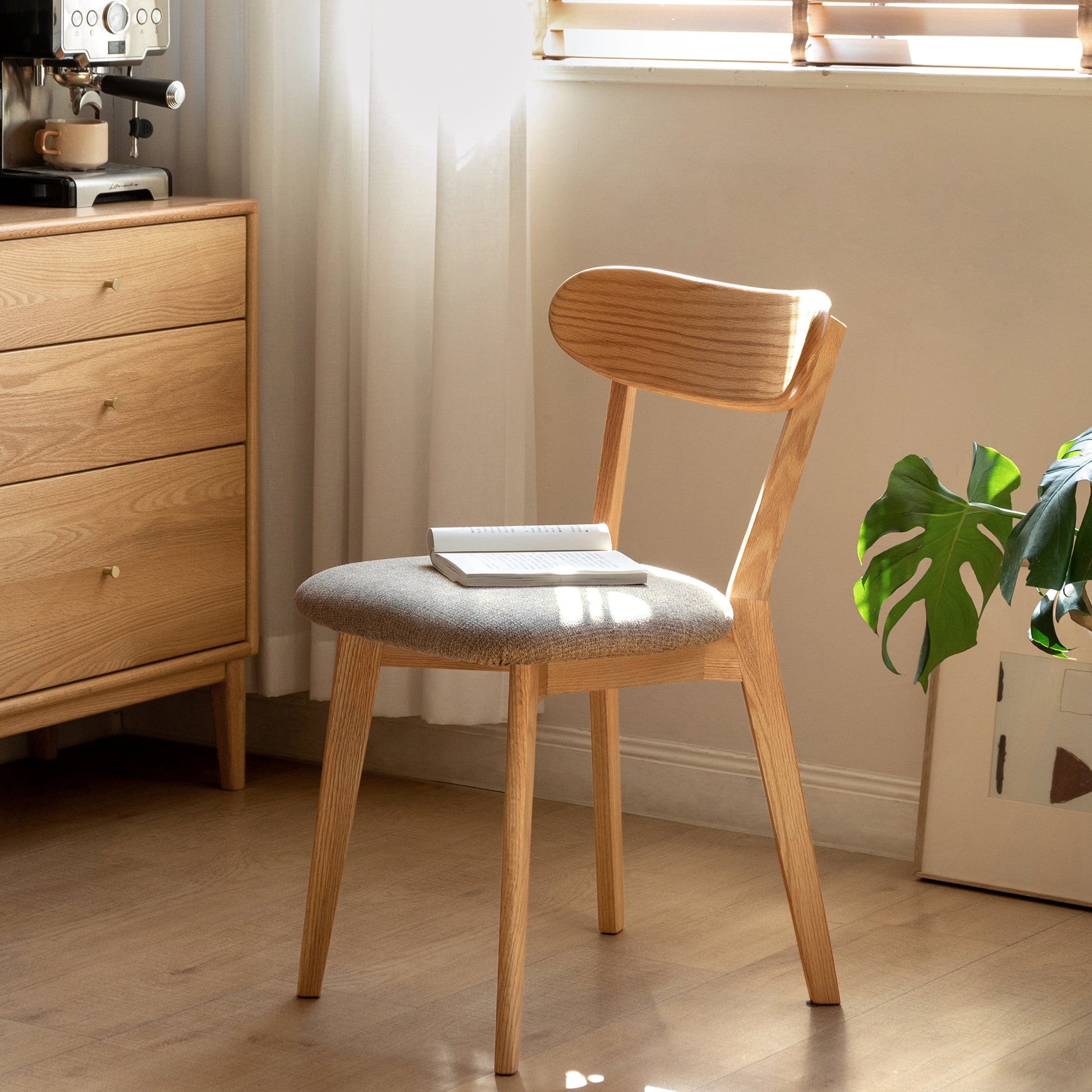 Modern wooden dining chair with grey upholstered seat and curved back
