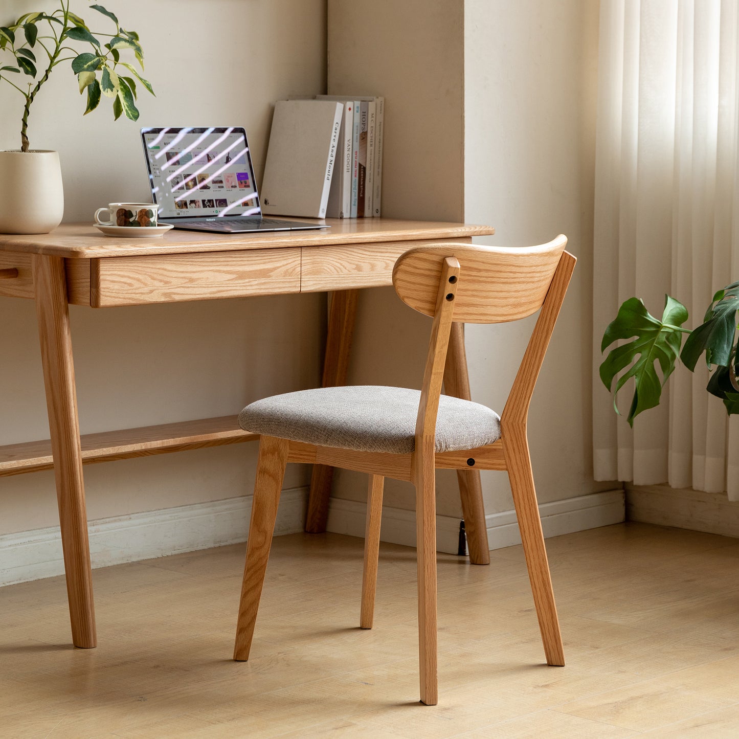 Light wood dining chair with grey upholstered seat and curved back