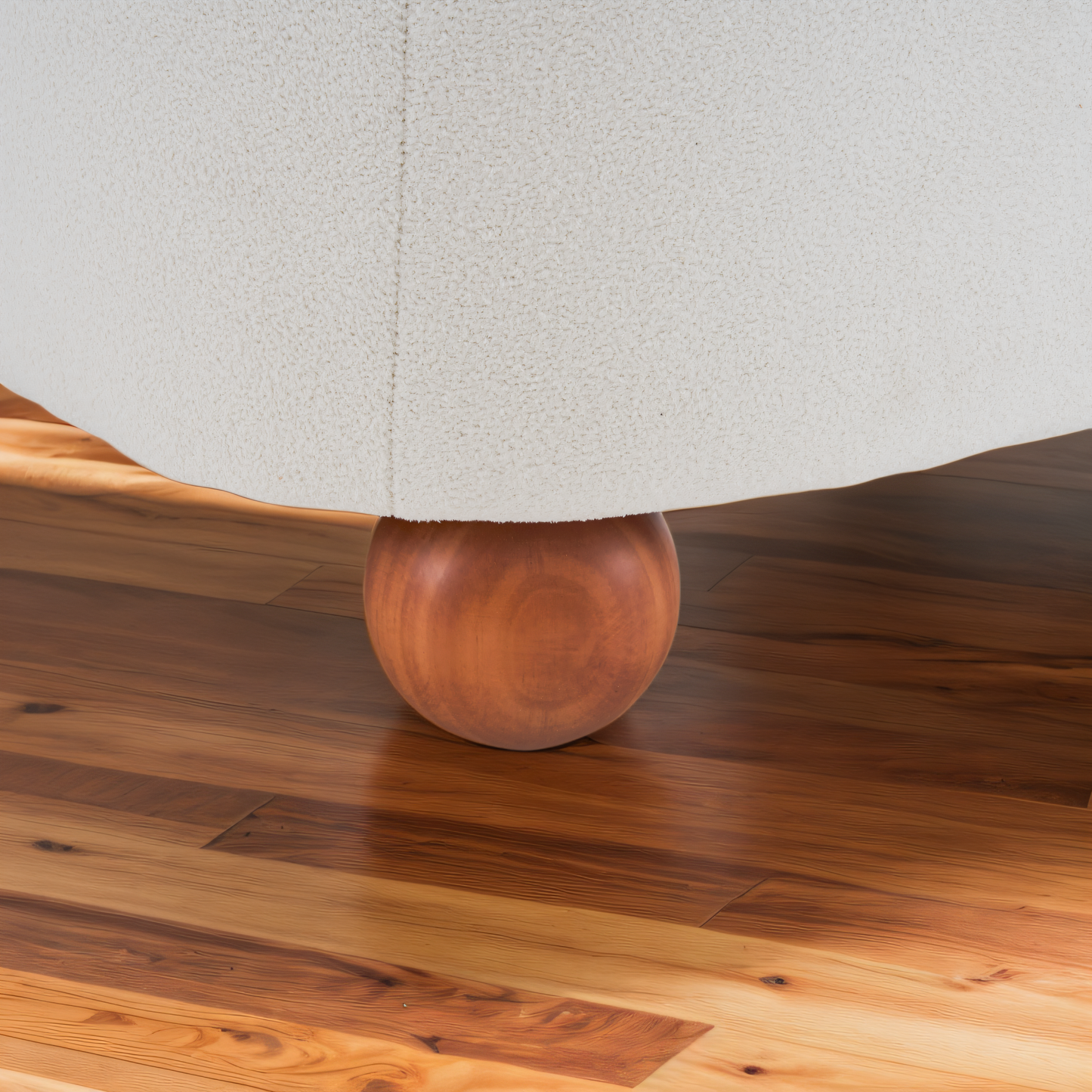 Closeup of a textured cream fabric upholstery on a spherical wooden furniture leg