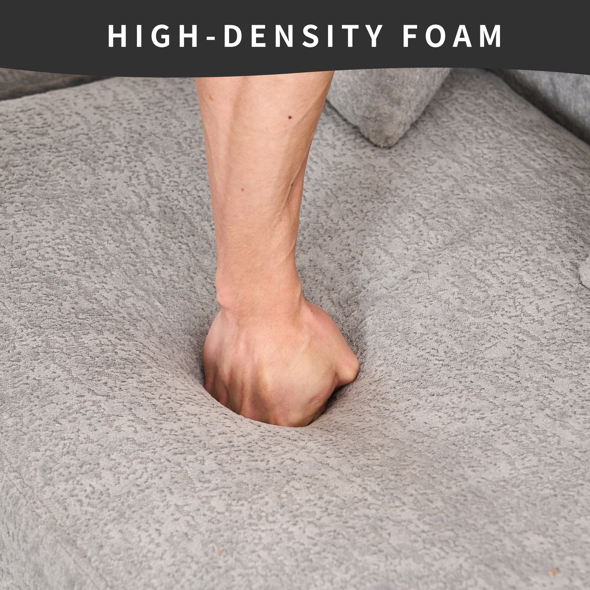 Hand pressing into plush gray highdensity foam cushion